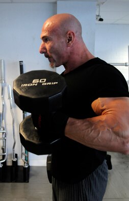 John Wales, a fitness instructor at the Lakenheath gym, busts out a set of curls to train for the National Amateur Body Builders Association British National Competition, May 19.  Wales has been participating in these events for nearly 40 years.  (U.S. Air Force photo by Staff Sgt. Christopher L. Ingersoll)