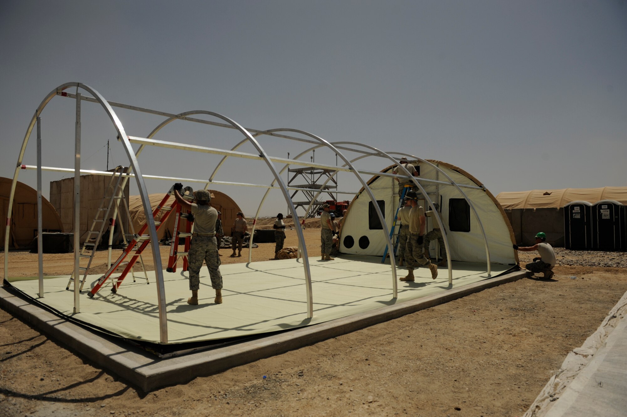 U.S. Air Force members of the 72nd Expeditionary Air Control Squadron, 451st Air Expeditionary Group, Kandahar Air Field, Afghanistan, set up a tent on May 17, 2009, in support of Operation Enduring Freedom. The Air Control Squadron is being built from the ground up to replace an outdated system being used currently at Kandahar Air Field.  (U.S. Air Force photo by Staff Sgt. James L. Harper Jr.)Released