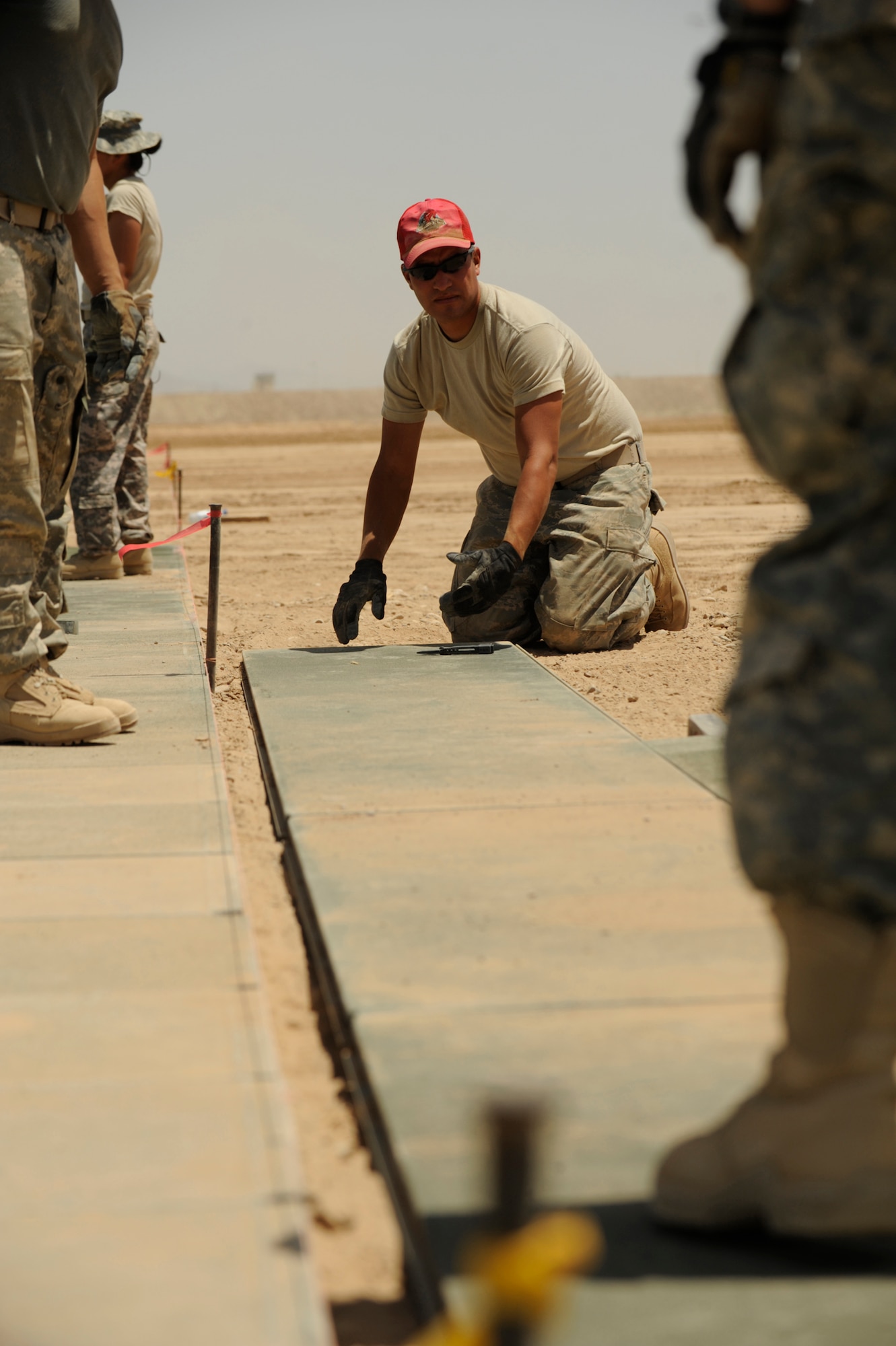 U.S. Air Force Staff Sgt. Michael Zamora (left), civil engineer electrician, 819th Expeditionary Red Horse Squadron, prepares AN2 matting at "mustang Ramp", Kandahar Air Field, Afghanistan, on May 17, 2009, in support of Operation Enduring Freedom.  The ramp will be used to bed down combat aviation brigade helicopter units.  (U.S. Air Force photo by Staff Sgt. James L. Harper Jr.)Released