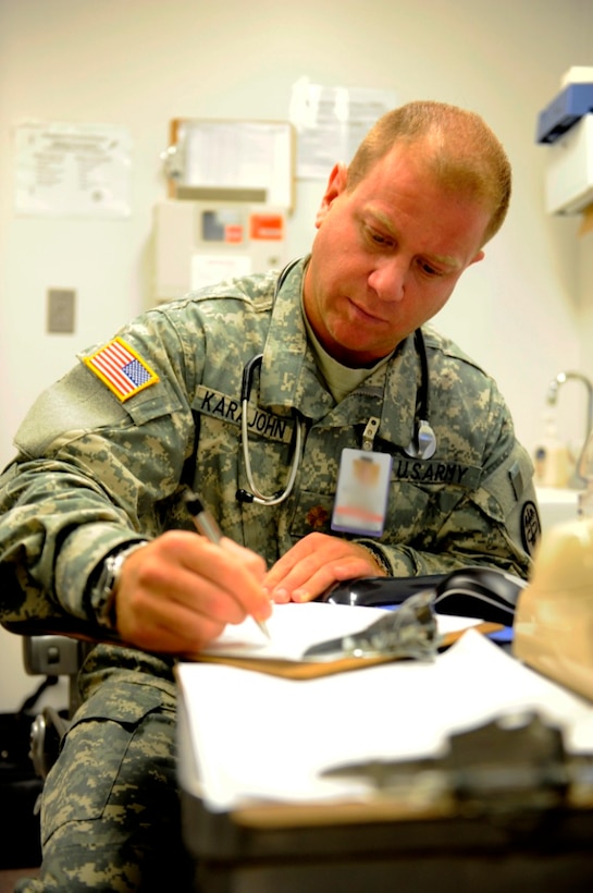 Army Maj. (Dr.) Nickolas Karajohn fills out medical data for a patient at the troop medical clinic at Camp Atterbury, Ind. Karajohn, a practicing physician at work, is known off the clock as rapper “M.C. M.D.” U.S. Army photo by Sgt. Robert G. Cooper III