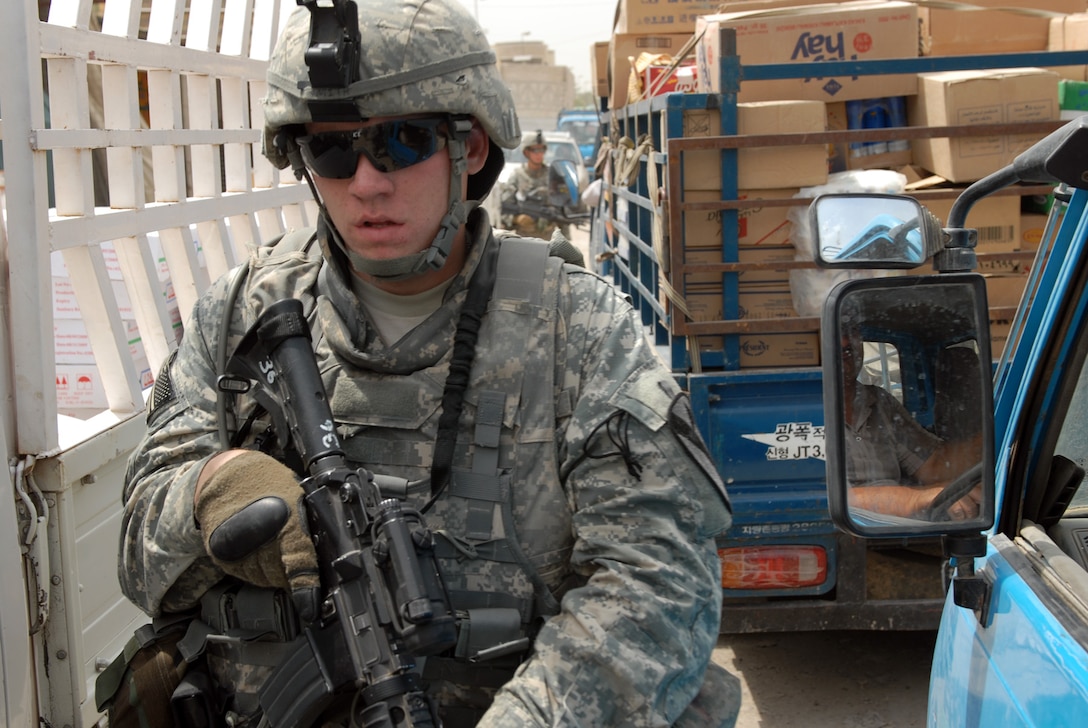 U.S. Army Pvt. Justin Smith walks through a traffic jam while on patrol in Sadr City, Iraq, May 27, 2009. Smith is a combat medic assigned to the 1st Cavalry Division's Company B, 2nd Battalion, 5th Cavalry Regiment, 1st Brigade Combat Team.