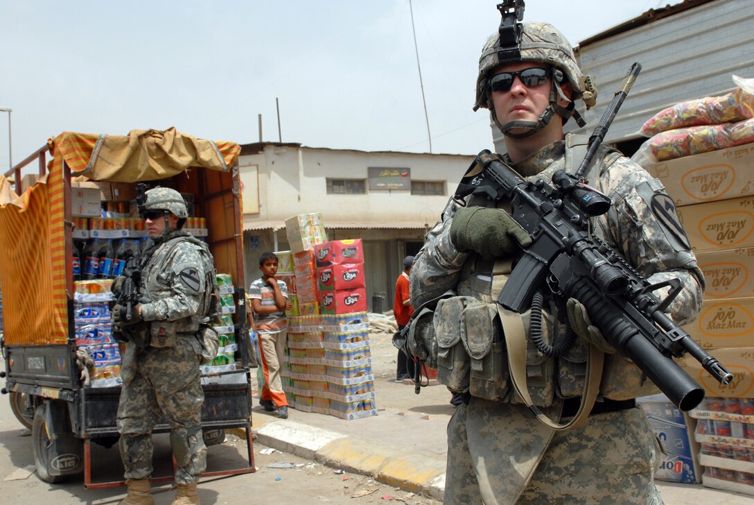 U.S. Army Pvt. Justin Smith, left, a combat medic and Cpl. Shane Smith, right, an infantryman team leader, maintain a lookout while on patrol in Sadr City, Iraq, May 27, 2009. The two are assigned to the 1st Cavalry Division's Company B, 2nd Battalion, 5th Cavalry Regiment, 1st Brigade Combat Team, which is performing more joint patrols with Iraqi soldiers in preparation to transfer Joint Security Station Sadr City to Iraqi control.

