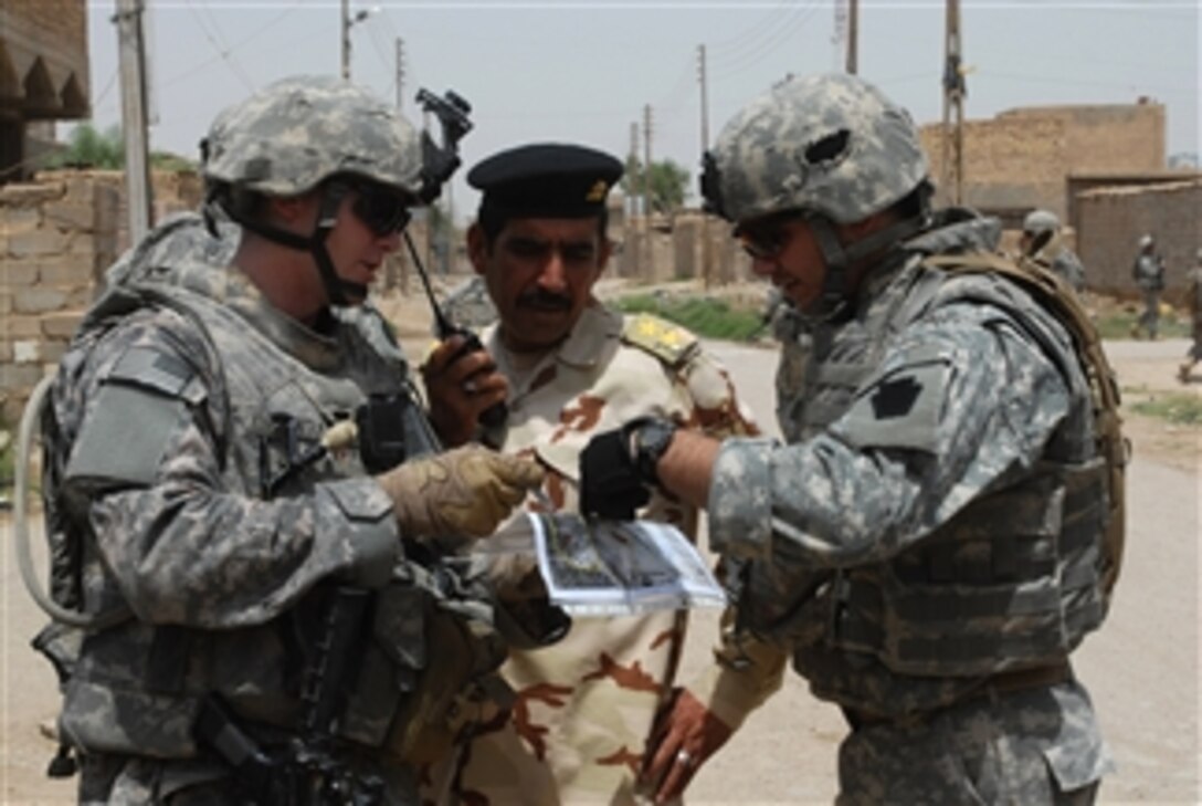 U.S. Army 1st Lt. Fredrick Santucci, attached to 2nd Brigade, 1st Infantry Division, and an Iraqi army officer plan a patrol route through the city of Abu Ghraib, Nassir Wa Salam province, Iraq, on May 17, 2009.  
