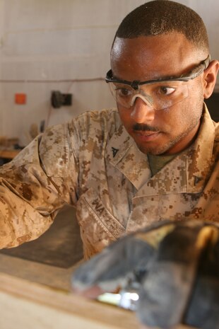 Lance Cpl. Micheal Waters, a packing specialist with the Preservation, Package, and Packaging (P3) section, 2nd Supply Battalion, 2nd Marine Logistics Group (Forward), measures a piece of wood while constructing a shipping box aboard Al Asad, Iraq, June 2, 2009. Waters is one of only five Marines assigned to the P3 section at Al Asad who are responsible for packaging gear, personal effects and equipment for shipment to locations around the world. (U.S. Marine Corps photograph by Gunnery Sgt. Katesha Washington)
