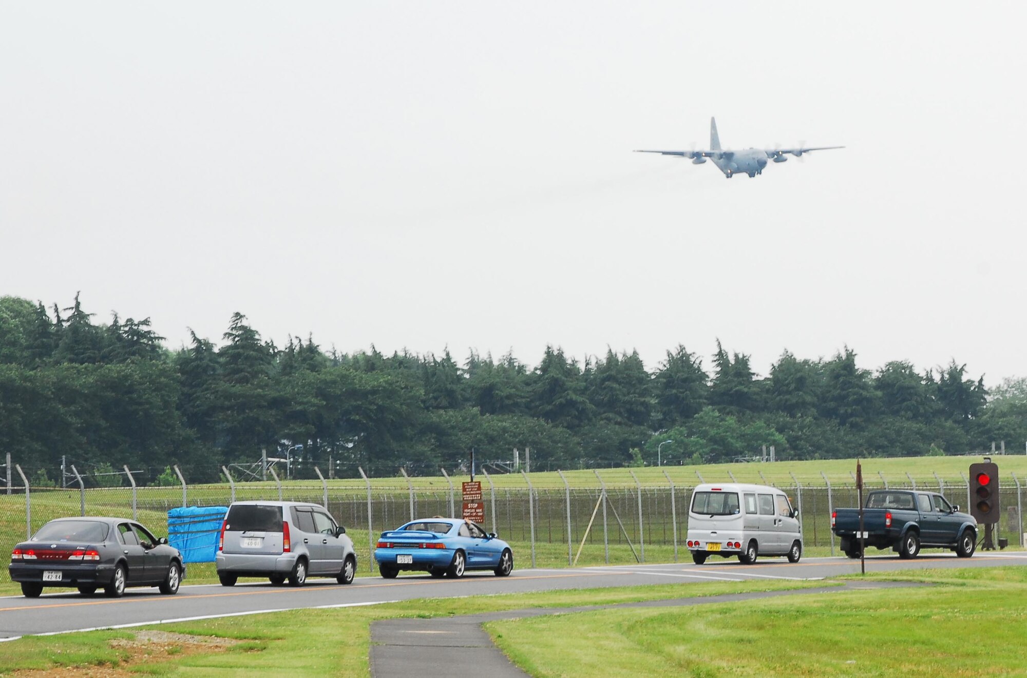 YOKOTA AIR BASE, Japan -- A line of cars form on the North Overrun as a C-130 Hercules makes its approach May 27. (U.S. Air Force photo/Airman Sean Martin)
