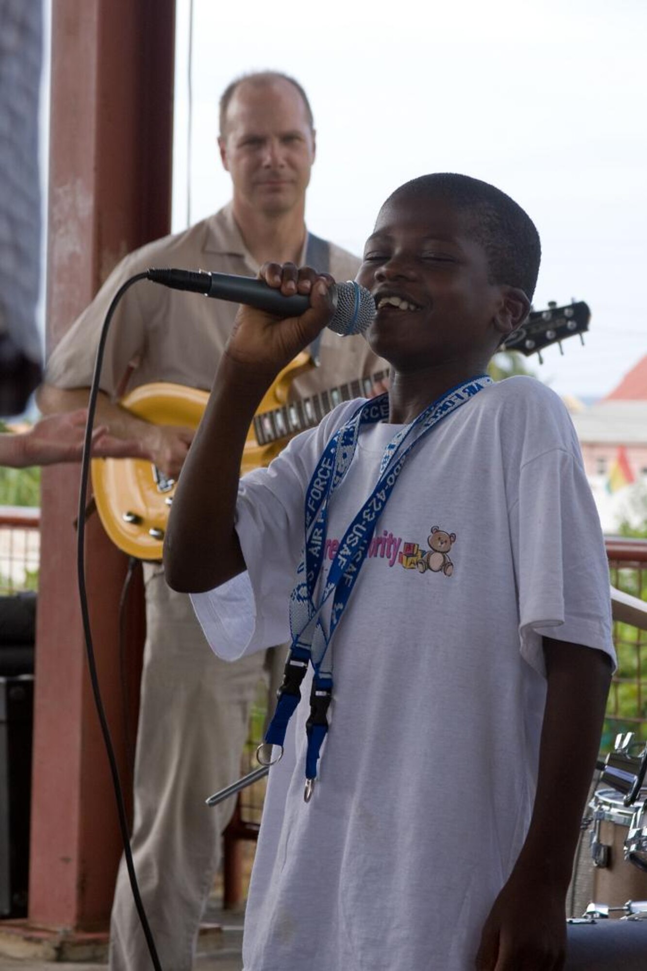 VICTORIA, Grenada -- An orphan from the Father Mallaghan’s Home for Boys sings along with the U.S. Air Force Academy Band “Blue Steel” in Victoria, Grenada, June 1. Blue Steel spent the day with orphans from Father Mallaghan’s Home for Boys before performing a public concert in the center of the village.  The community outreach event is part of Operation Southern Partner, an Air Forces Southern-led event aimed at strengthening partnerships with nations in the U.S. Southern Command area of focus through mil-to-mil subject matter exchanges.  In addition to the exchange program, Airmen also had the opportunity to volunteer at various charitable and community organizations in each host nation.  (Photo courtesy of Sagar Pathak of HorizontalRain.com)