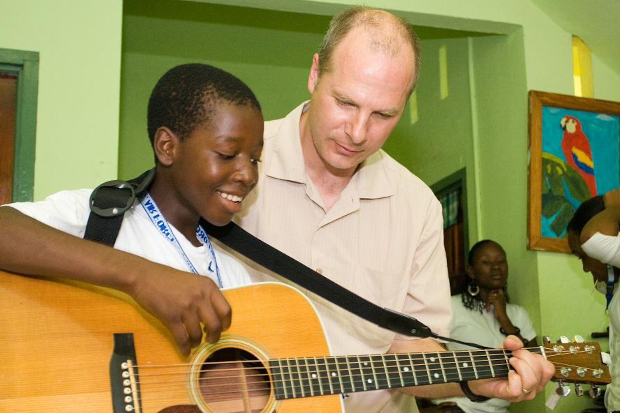VICTORIA, Grenada -- Tech Sgt. Stephen Brannen, a guitar player with the Air Force Academy Band “Blue Steel,” instructs an orphan at Father Mallaghan’s Home for Boys in Victoria, Grenada June 1.  Blue Steel spent the day with boys at the home before performing a public concert in the center of the village.  The community outreach event is part of Operation Southern Partner, an Air Forces Southern-led event aimed at strengthening partnerships with nations in the U.S. Southern Command area of focus through mil-to-mil subject matter exchanges.  In addition to the exchange program, Airmen also had the opportunity to volunteer at various charitable and community organizations in each host nation.  (Photo courtesy of Sagar Pathak of HorizontalRain.com)
