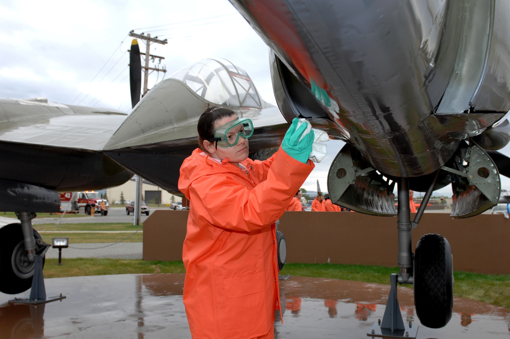 ELMENDORF AIR FORCE BASE, Alaska -- Airman 1st Class Amber Davis, 3rd Medical Support Squadron, finishes polishing the bottom of the McCloud Memorial P-38 May 27. Volunteers clean the static displays every early summer and fall in Heritage Park. (U.S. Air Force photos/Tech. Sgt. Brian Smith)
