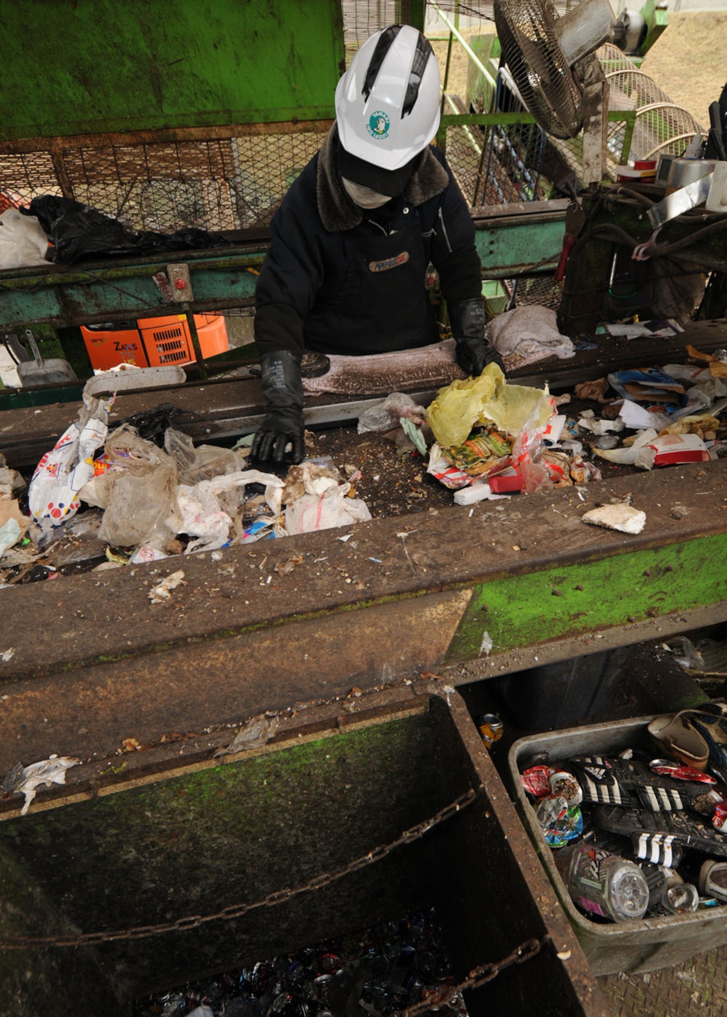 YOKOTA AIR BASE, Japan -- Japanese workers at the recycling center sift through trash thrown out by the Yokota community. The workers do this to ensure recyclable material is separated from any items considered unrecyclable. The recycling program is just one of the proactive environmental issues the personnel at the 374th Civil Engineer Squadron's environmental flight uses in determining compliance with environmental laws. (U.S. Air Force photo/Senior Airman Vernonica Pierce)