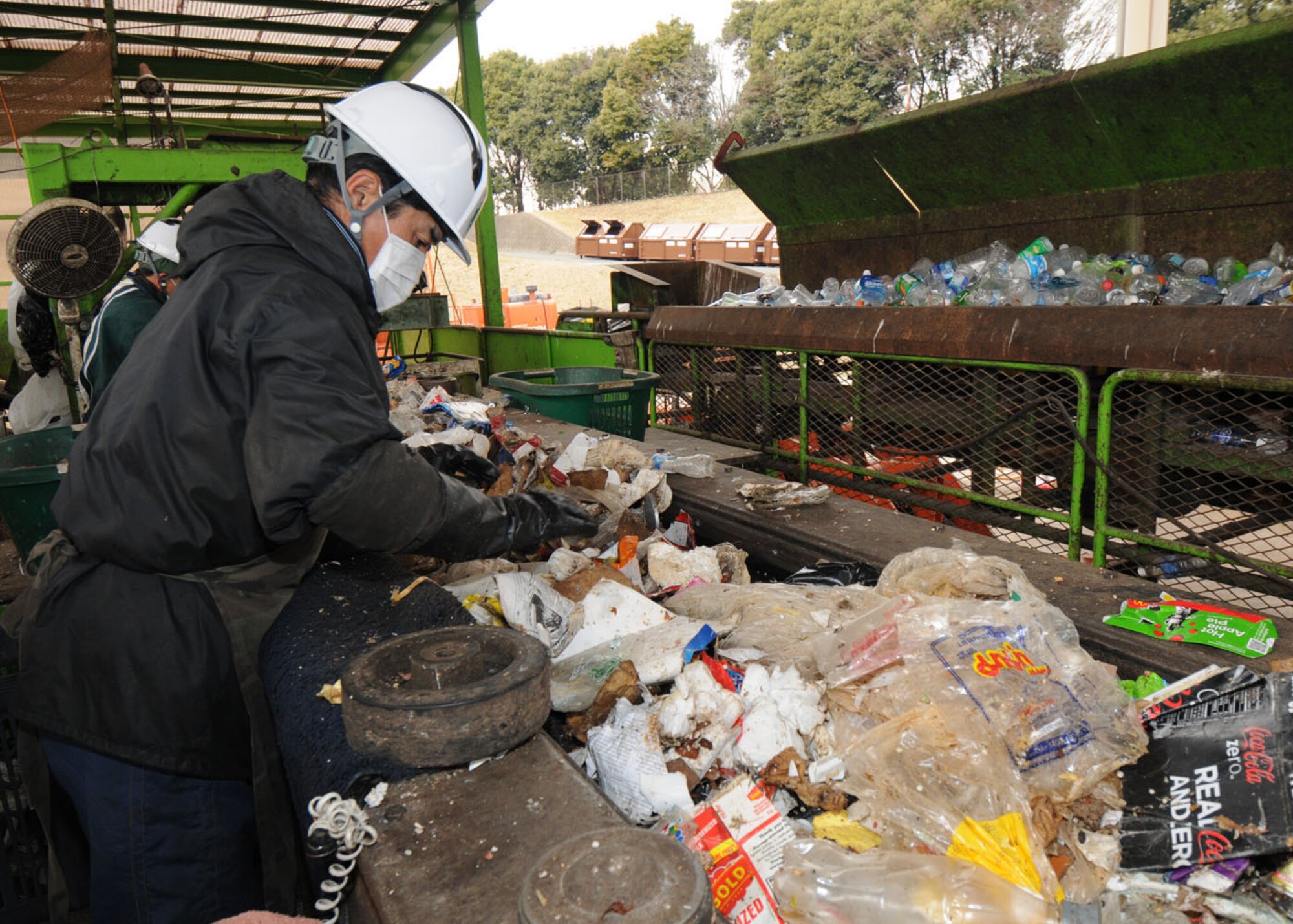 YOKOTA AIR BASE, Japan -- Japanese workers at the recycling center sift through trash thrown out by the Yokota community. The workers do this to ensure recyclable material is separated from any items considered unrecyclable. The recycling program is just one of the proactive environmental issues the personnel at the 374th Civil Engineer Squadron's environmental flight uses in determining compliance with environmental laws. (U.S. Air Force photo/Senior Airman Vernonica Pierce)