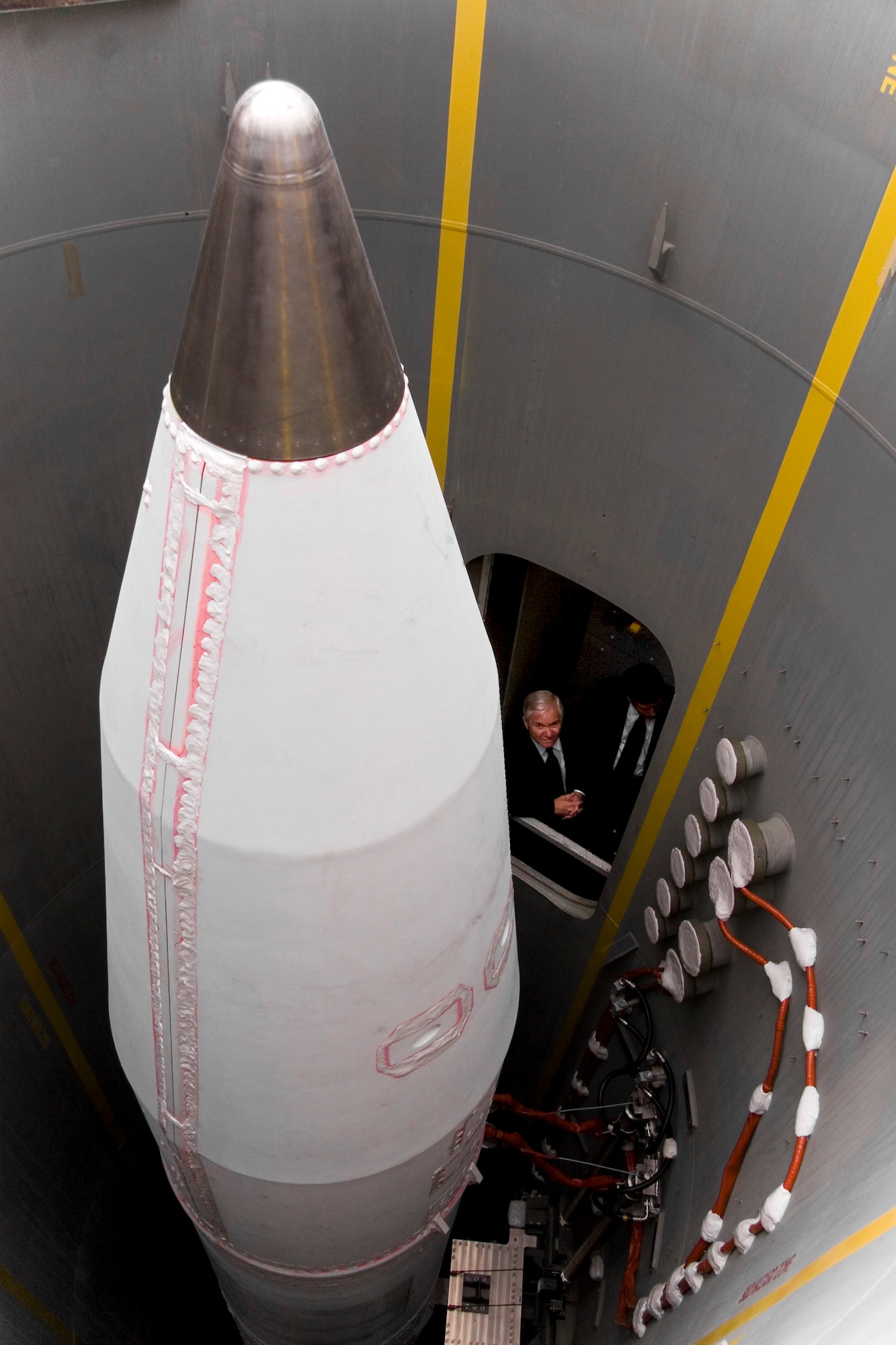 (FORT GREELY, Alaska) -- Defense Secretary Robert Gates peers out of a Silo Interface Fault at an operational ground-based interceptor during a visit to the Missile Defense Complex on Fort Greely, Alaska. Secretary Gates saw the nation's operational arm of its strategic missile defense capability and the Soldiers of the 49th Missile Defense Battalion (Ground-based Midcourse Defense) who are charged with defending the nation during a visit June 1. The 100th MDB (GMD) is stationed at Peterson Air Force Base and is a Colorado National Guard unit assigned to U.S. Space and Missile Defense Command, under the operational control of Northern Command for homeland defense. (U.S. Army photo by Sgt. Jack Carlson III)