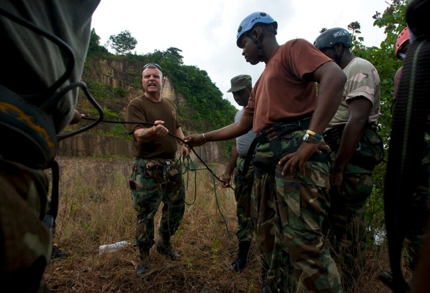 Pararescueman Senior Master Sgt. Michael Fleming (center) conducts safety checks on rappelling harnesses to members of the Royal St. Lucia police force's special service unit June 1 during a subject matter expert exchange on mountaineering and high angle recovery rescue procedures for Operation Southern Partner in La Toc, St. Lucia. (U.S. Air Force photo/Staff Sgt. Bennie J. Davis III)