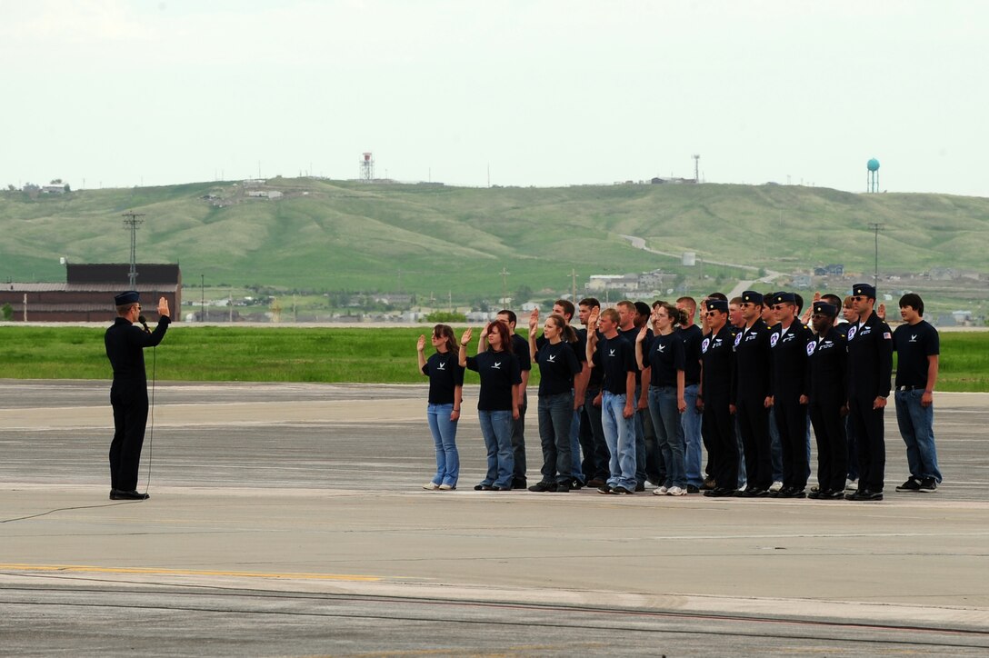 Lt. Col. Greg Thomas, U.S. Air Force Thunderbirds commander, recites the oath of enlistment for a group of young men and women here, May 30.  The young men and women were accompanied by the five other pilots of the Thunderbirds during the ceremony. (U.S. Air Force photo/Senior Airman Anthony Sanchelli)