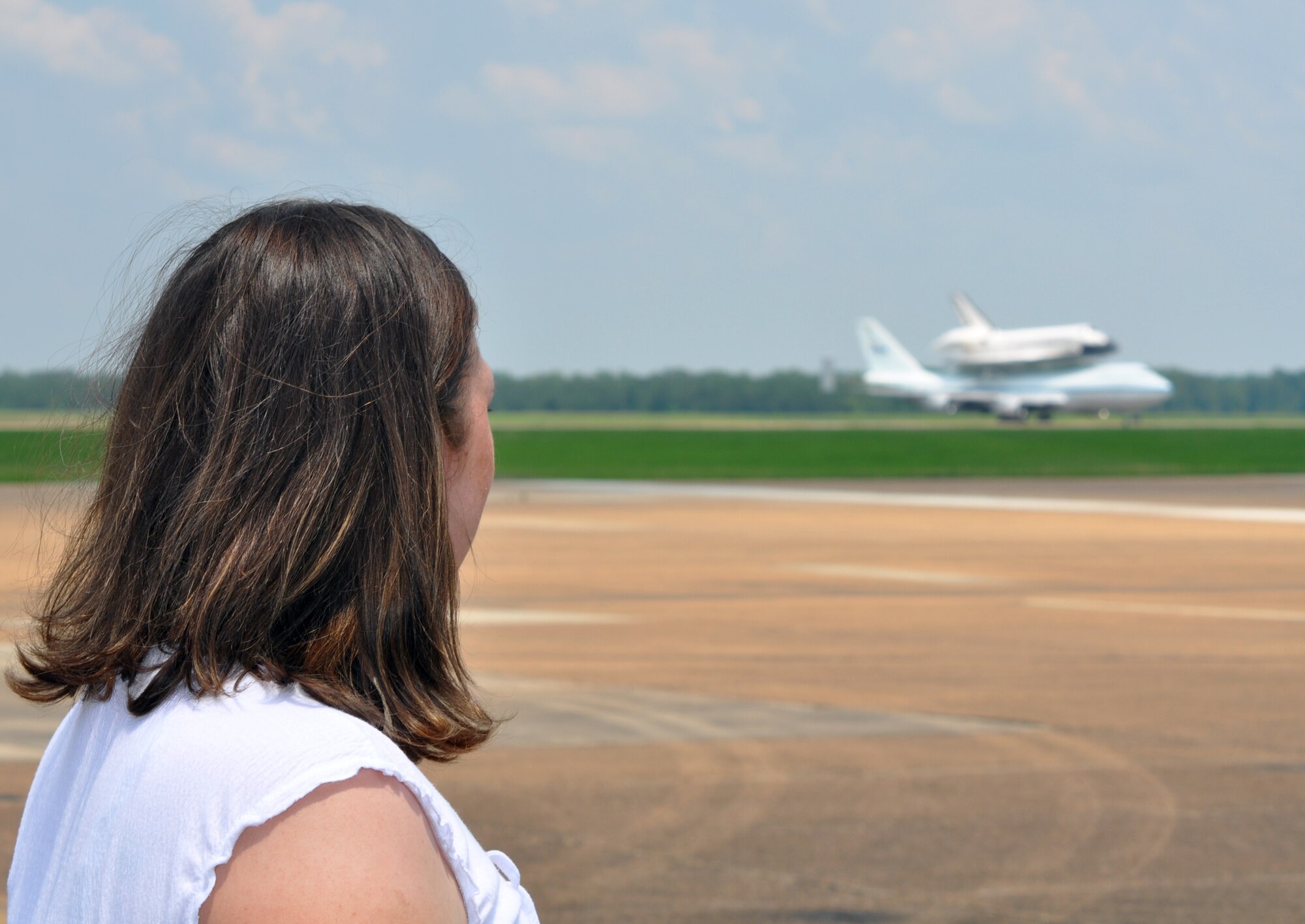 Erinn Benge watches as the Space Shuttle Atlantis, riding atop a modified Boeing 747 Shuttle Carrier Aircraft, taxis after landing at Columbus Air Force Base June 2. Columbus AFB was the shuttle’s final stop for fuel before finishing its journey to Kennedy Space Center, Fla. (U.S. Air Force photo/Senior Airman Jacob Corbin). 