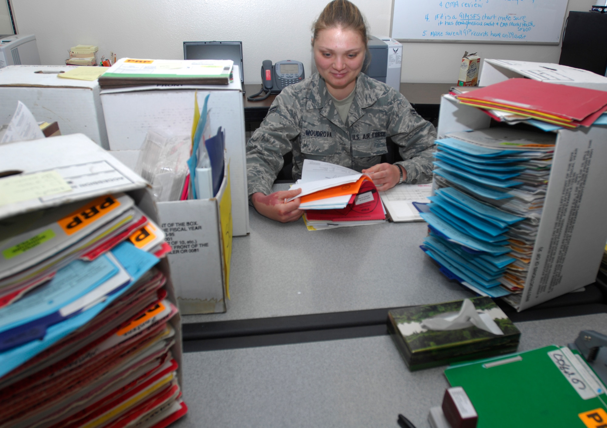 MINOT AIR FORCE BASE, N.D. -- Airman First Class Elena Moudrova, a medical technician in the Personal reliability Program clinic sorts through just a few of the hundreds of files for the members who are on PRP.  The program is designed to ensure that each member who performs duties involving nuclear weapons meet certain criteria to guarantee the safety, security and reliability of nuclear asset. Due to the programs strict guidelines Airmen on PRP status must see specialized doctors than others whom are not.( U.S. Air force Photo by Staff Sgt. Stacy Moless)