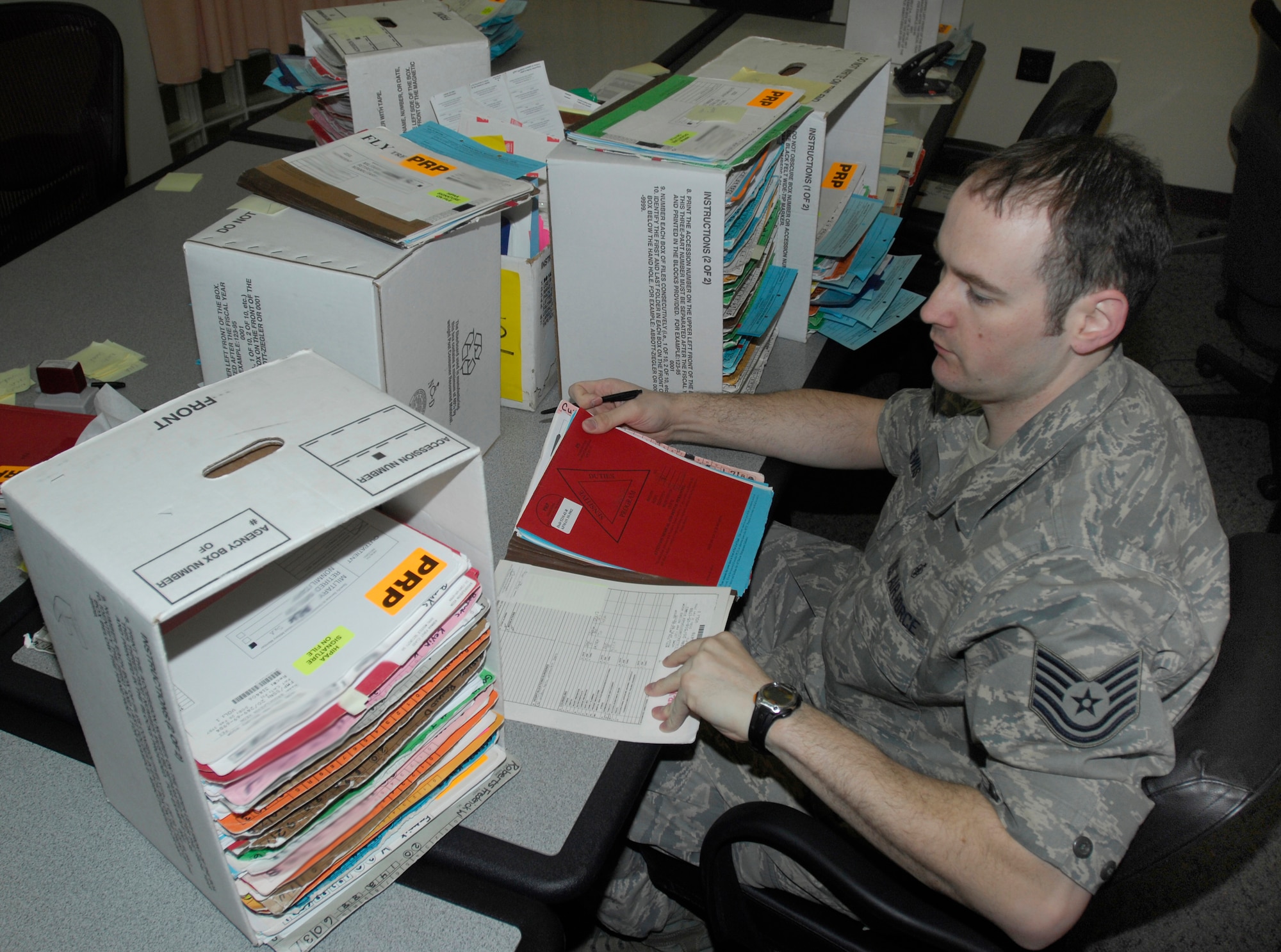 MINOT AIR FORCE BASE, N.D. -- Tech. Sgt. William Lewis, a medical technician in the Personal reliability Program clinic sorts through just a few of the hundreds of files for the members who are on PRP.  The program is designed to ensure that each member who performs duties involving nuclear weapons meet certain criteria to guarantee the safety, security and reliability of nuclear asset. Due to the programs strict guidelines Airmen on PRP status must see specialized doctors than others whom are not. ( U.S. Air force Photo by Staff Sgt. Stacy Moless)