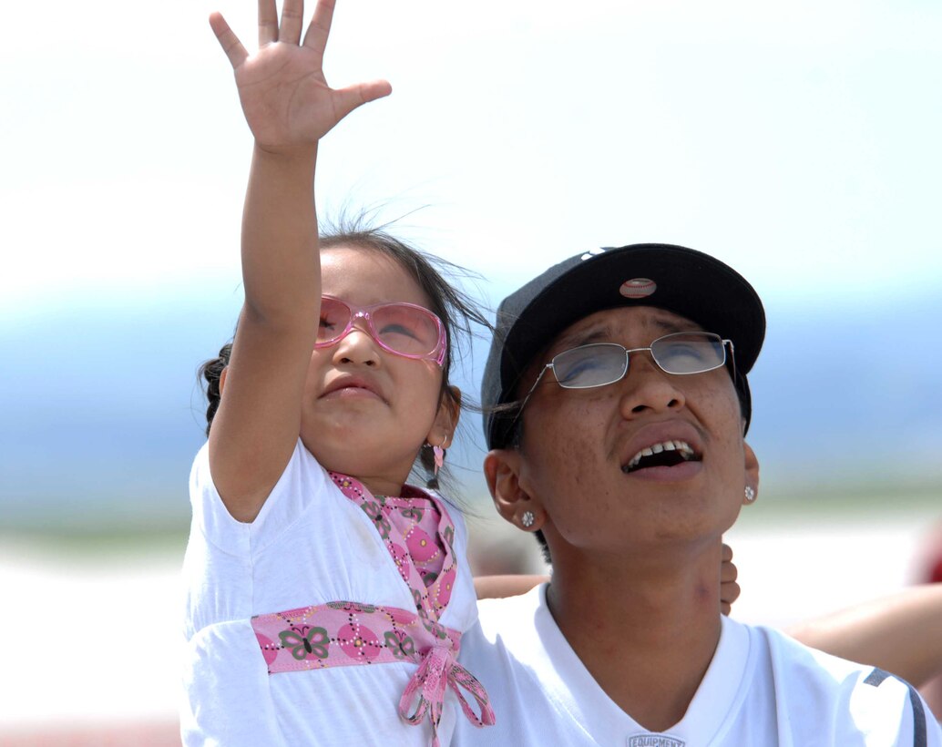(Right) Kenny One Skunk and daughter Lakee Sitting Crow, watch as the B-25 Mitchell flys in the Dakota Thunder open house air show here, May 30. The event featured multiple static displays as well as aerial demonstrations from the U.S. Air Force Thunderbirds and the U.S. Army Black Daggers parachute demonstration team. (U.S. Air Force photo by Airman 1st Class Corey Hook)