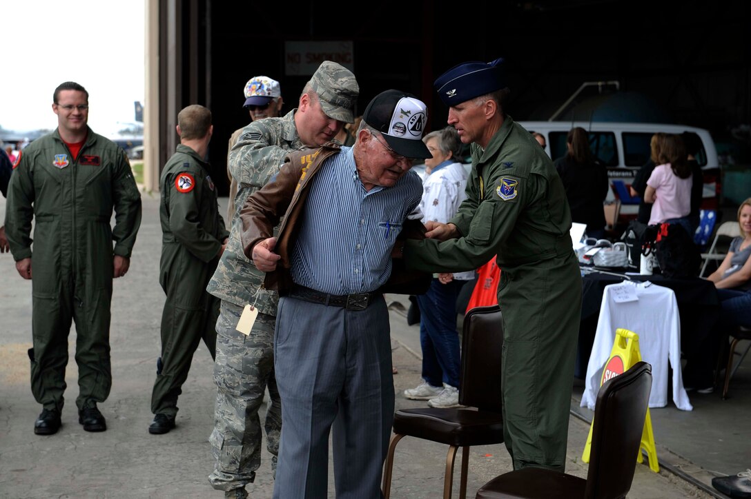 Tech. Sgt. Steven Wilson, 28th Bomb Wing Public Affairs NCO in charge, and Col. Scott Vander Hamm, 28th Bomb Wing commander, help Clayton Bejot, B-17 Flying Fortress pilot from World War ll, put on his "Flak Dodger" jacket during the Dakota Thunder open house and air show here, May 30. Sergeant Wilson, who is also the South Dakota Air and Space Museum director, began searching for Mr. Bejot's whereabouts after finding a picture of the pilot in a book written about this particular B-17. The jacket still contains the artwork depicting all of Mr. Bejot's missions over Europe and the words "Flak Dodger" written on the back. (U.S. Air Force photo by Airman 1st Class Corey Hook)