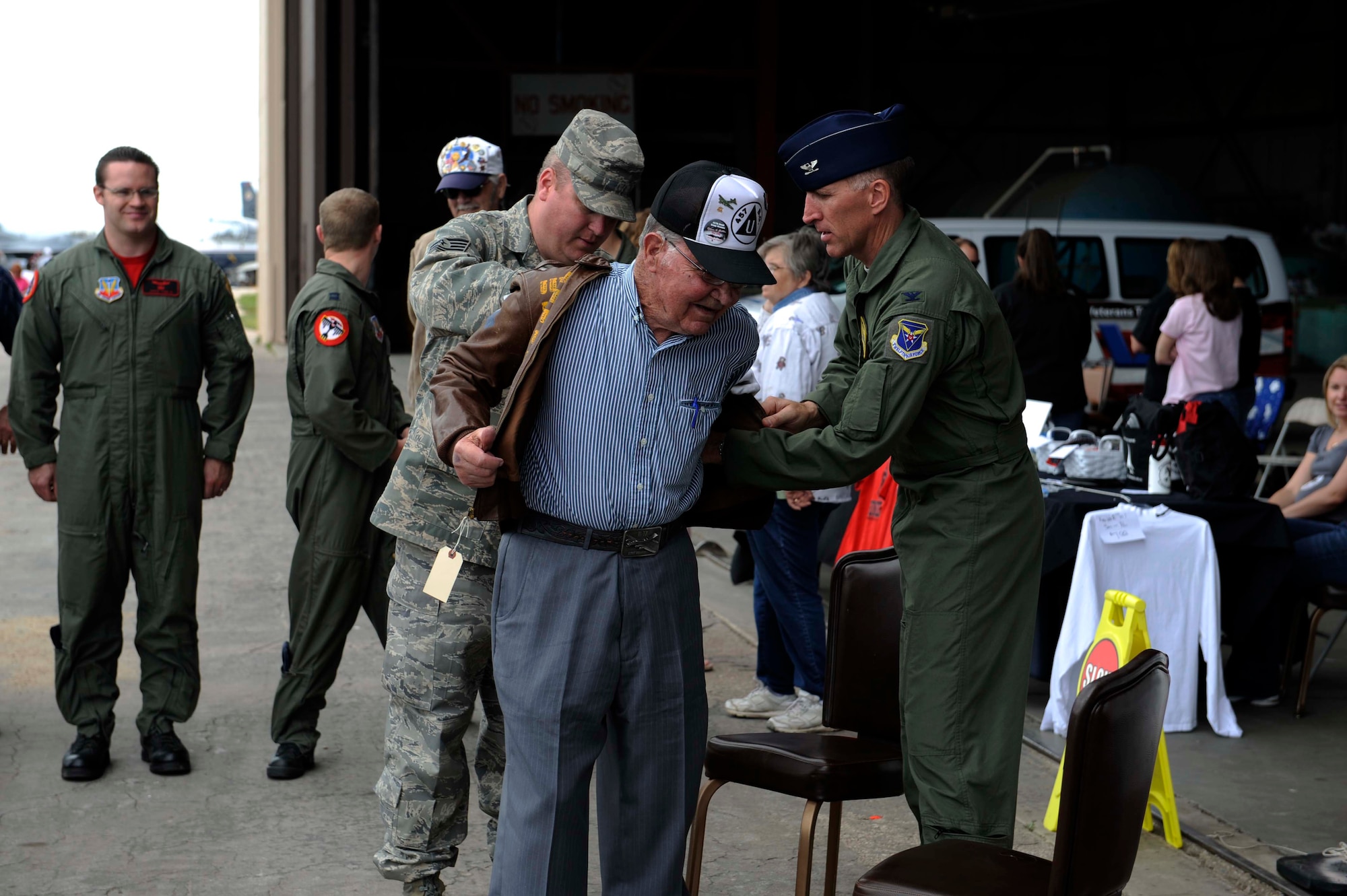 Tech. Sgt. Steven Wilson, 28th Bomb Wing Public Affairs NCO in charge, and Col. Scott Vander Hamm, 28th Bomb Wing commander, help Clayton Bejot, B-17 Flying Fortress pilot from World War ll, put on his "Flak Dodger" jacket during the Dakota Thunder open house and air show here, May 30. Sergeant Wilson, who is also the South Dakota Air and Space Museum director, began searching for Mr. Bejot's whereabouts after finding a picture of the pilot in a book written about this particular B-17. The jacket still contains the artwork depicting all of Mr. Bejot's missions over Europe and the words "Flak Dodger" written on the back. (U.S. Air Force photo by Airman 1st Class Corey Hook)