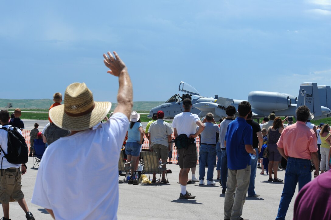 Spectators wave to the A-10 Thunderbolt II pilot after his air demonstration during the 2009 Dakota Thunder open house and air show here, May 31. The open house contained many displays and demonstrations both on and off the ground. (U.S. Air Force photo/Senior Airman Kasey Zickmund)