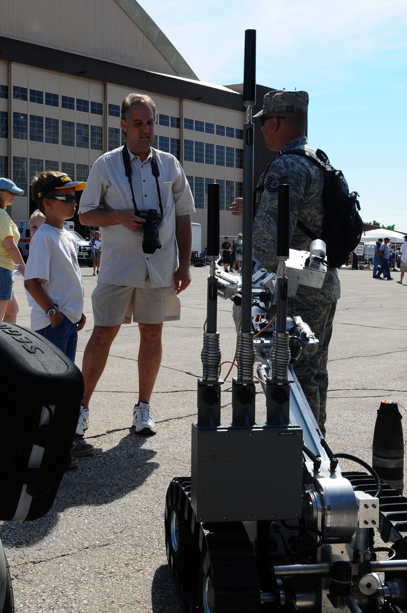 Tech. Sgt. Charles Riedel, 28th Civil Engineer Squadron explosive ordnance disposal flight superintendant, talks to Eric Helgeson, attendee from Rapid City, S.D., and his son, Ian, about the EOD flight and their mission during 2009 Dakota Thunder open house and air show, May 31. The open house contained many displays and demonstrations both on and off the ground. (U.S. Air Force photo/Senior Airman Kasey Zickmund)