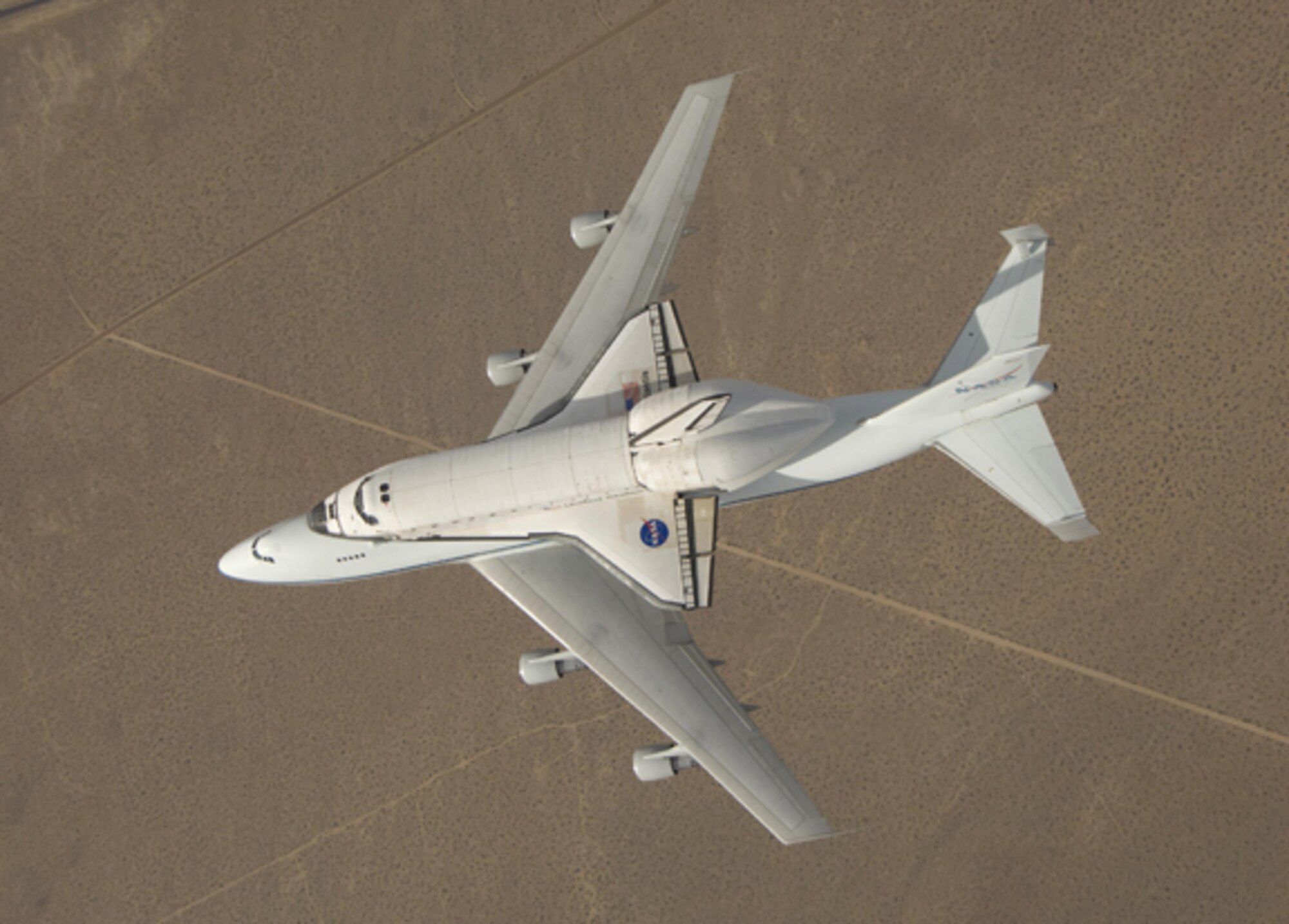 NASA Dryden photographer Jim Ross captured this overhead view of Space Shuttle Atlantis atop NASA's modified 747 carrier aircraft over California's high desert from an F/A-18 Hornet mission support aircraft after departing Edwards Air Force Base on a ferry flight back to the Kennedy Space Center in Florida. (NASA Photo/Jim Ross)