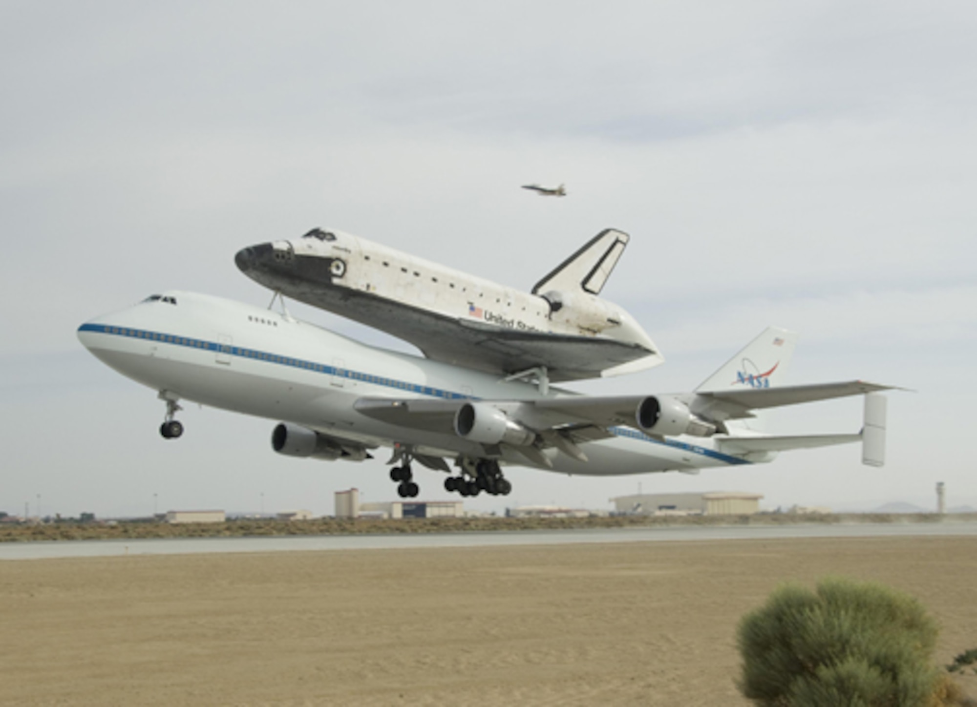 NASA 911, a Boeing 747 modified to carry the space shuttle, lifts off Runway 22 at Edwards Air Force Base carrying the shuttle Atlantis on its back on the first leg of Atlantis' ferry flight back to the Kennedy Space Center in Florida. (NASA photo/Tom Tschida)