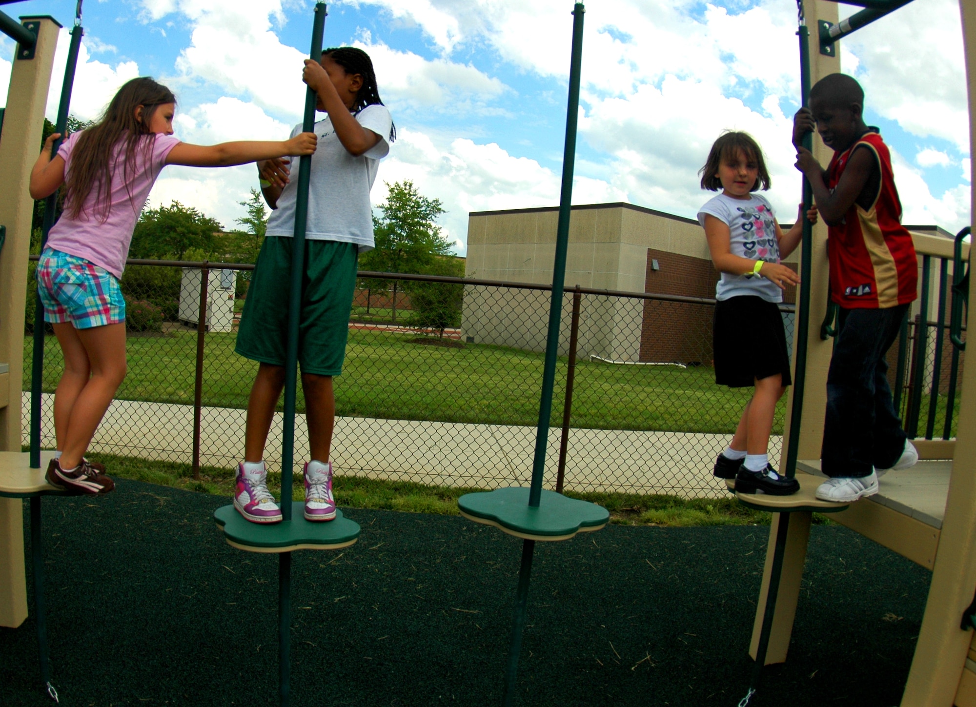 Children test the new playground equipment May 29, 2009, at the Bolling Youth Center during their after school program before the recreation area official opening on Bolling Air Force Base. The playground was made entirely of recycled materials as part of the Family Member Program’s campaign to teach children about environmental awareness. (U.S. Air Force photo by Airman 1st Class Katherine Windish)