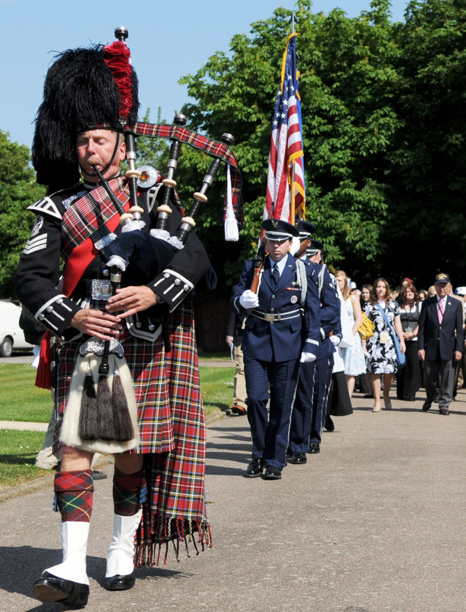Bagpiper Dave Harper followed by members of the honor guard from Royal Air Force Mildenhall, England, lead a precession of World War II veterans, students and faculty members from Missouri's College of the Ozarks to a ceremony June 1 at Thorpe Abbots, England. The airfield was the former home of the 100th Bomb Group. The group was in England on a tour of historic World War II sites coinciding with the 65th anniversary of the allied invasion of occupied France. (U.S. Air Force photo/Staff Sgt. Austin M. May) 

