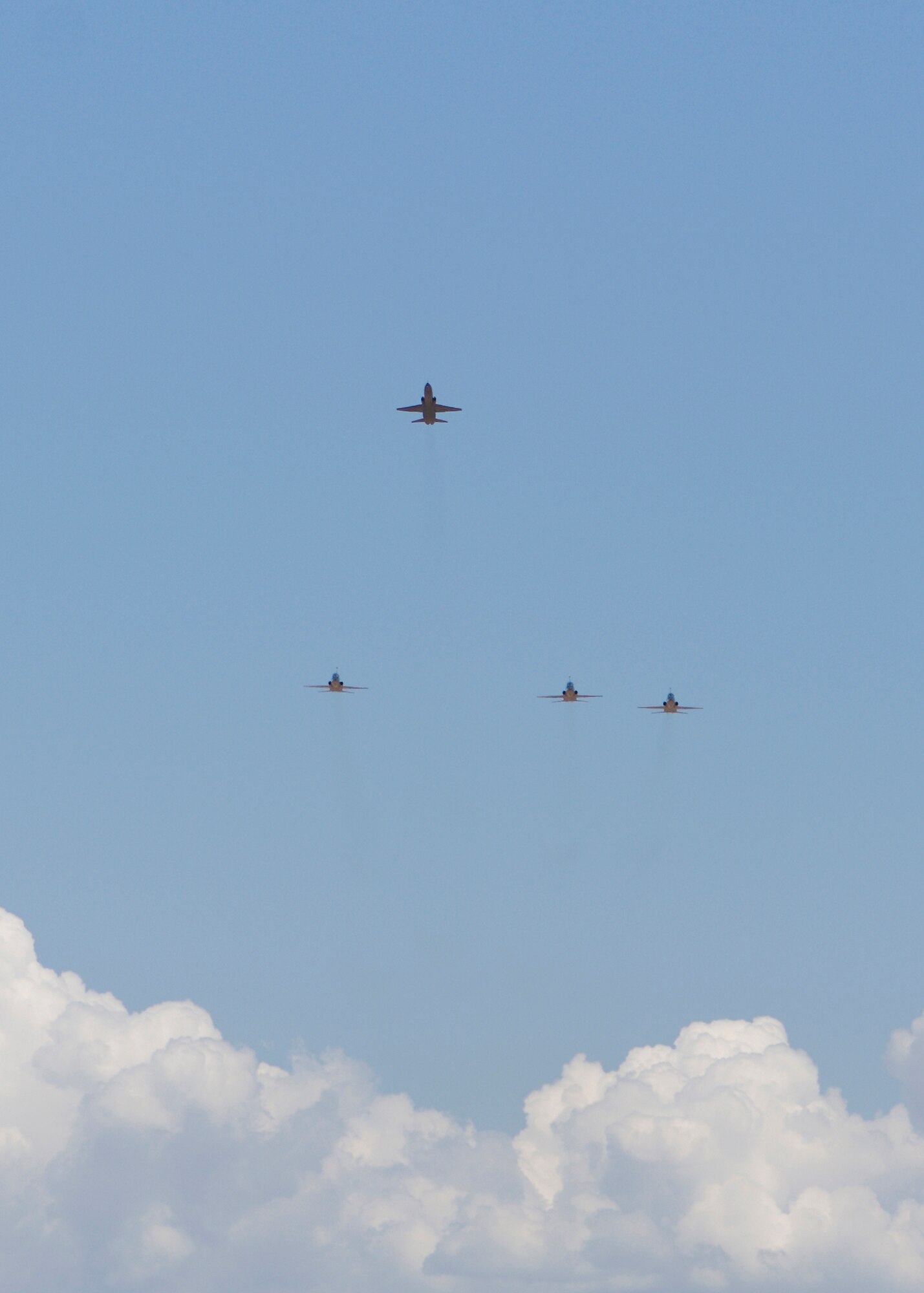A missing-man formation flies over Edwards during a memorial service for Maj. Mark Graziano May 28. Major Graziano, U.S. Air Force Test Pilot School Class 09-A student, died May 21 when his T-38 Talon crashed nine miles north of Edwards in the Mojave Desert during a student-test mission. (U.S. Air Force photo/Mike Cassidy)