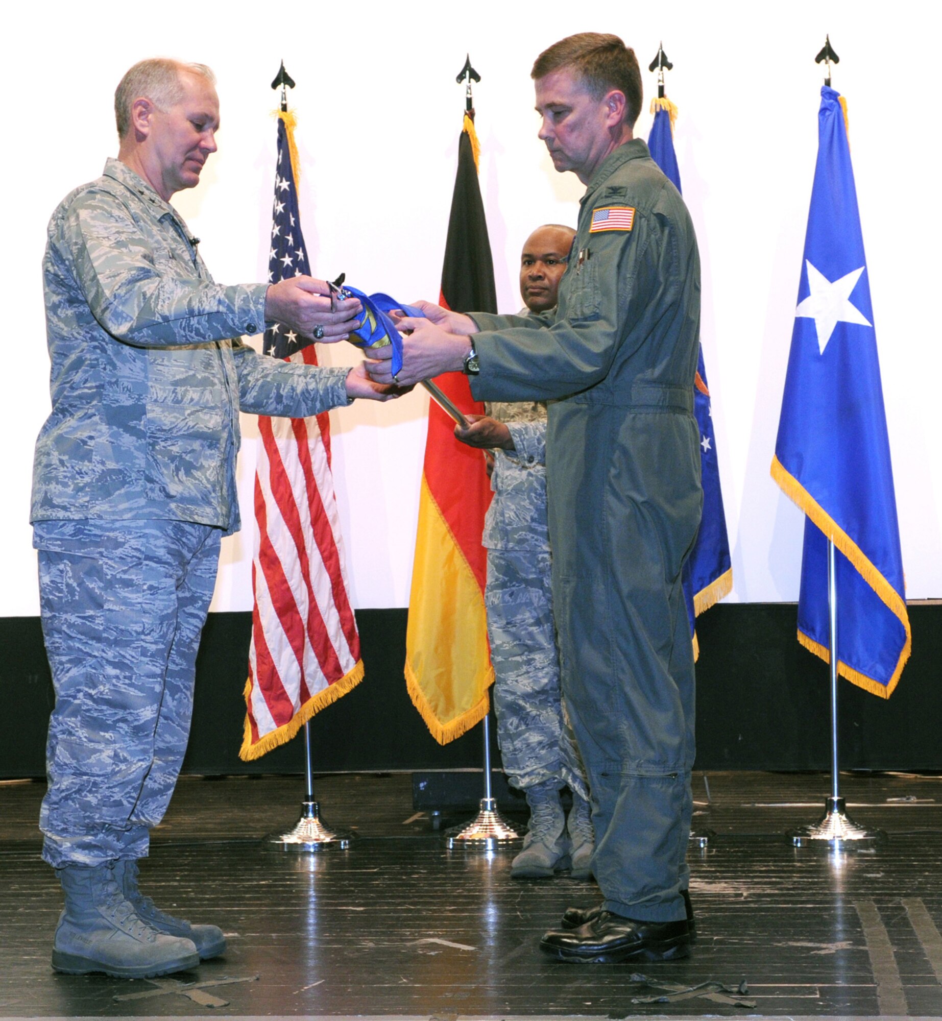 Maj. Gen. Ron Ladnier (left), 17th Air Force commander, and Col. Andy Redmond, the new 617th Air and Space Operations Center commander, unfurl the 617th flag at an activation ceremony May 29 at Ramstein Air Base, Germany, while Senior Master Sgt. Mike Topps, the new AOC superintendant,  assists. The ceremony marked the official standup of the AOC, the nerve center for command and control within 17th AF, the air component for U.S. Africa Command. The 617th AOC will oversee all air operations in the African area of activity. (U.S. Air Force  photo/Master Sgt. Jim Fisher)  