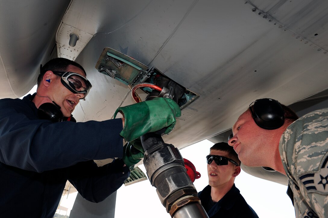 LANGLEY AIR FORCE BASE, Va. -- 1st Fighter Wing Command Chief Master Sgt. Kevin Slater connects a fuel hose to the bottom of an F-15C along with Senior Airman Ryan Turner, 1st Logistics Readiness Squadron patroleum oils and lubricant specialist, and Airman Mike Poudrier, 71st Aircraft Maintenance Unit F-15 crew chief, in effort to refuel the F-15C during a post flight inspection.  Chief Slater spent the afternoon with maintainers from the 71st Aircraft Maintenance Unit here June 1.  (U.S. Air Force photo/Senior Airman Vernon  Young)