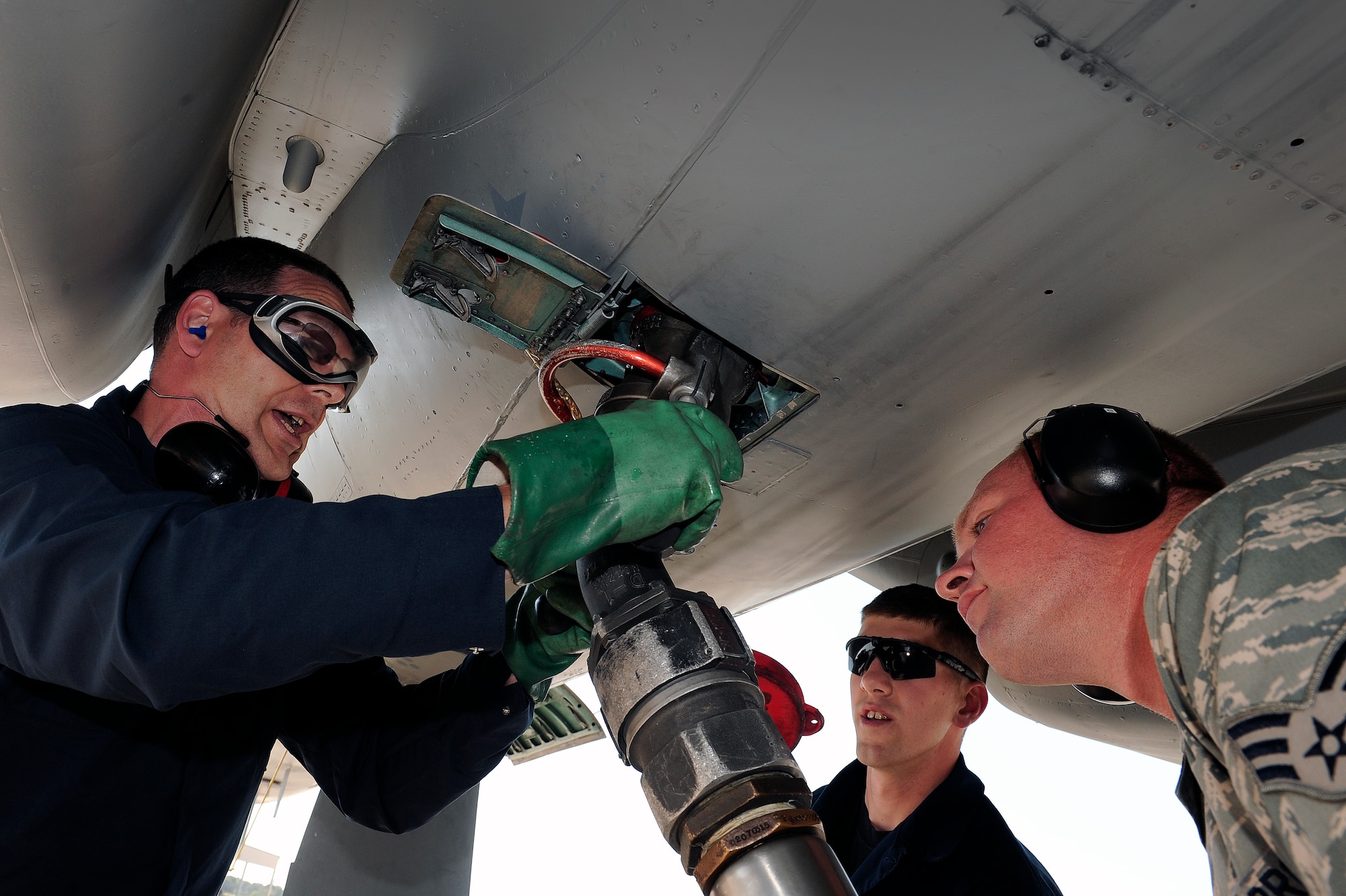 LANGLEY AIR FORCE BASE, Va. -- 1st Fighter Wing Command Chief Master Sgt. Kevin Slater connects a fuel hose to the bottom of an F-15C along with Senior Airman Ryan Turner, 1st Logistics Readiness Squadron patroleum oils and lubricant specialist, and Airman Mike Poudrier, 71st Aircraft Maintenance Unit F-15 crew chief, in effort to refuel the F-15C during a post flight inspection.  Chief Slater spent the afternoon with maintainers from the 71st Aircraft Maintenance Unit here June 1.  (U.S. Air Force photo/Senior Airman Vernon  Young)