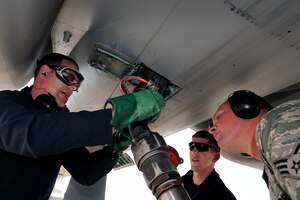 LANGLEY AIR FORCE BASE, Va. -- 1st Fighter Wing Command Chief Master Sgt. Kevin Slater connects a fuel hose to the bottom of an F-15C along with Senior Airman Ryan Turner, 1st Logistics Readiness Squadron patroleum oils and lubricant specialist, and Airman Mike Poudrier, 71st Aircraft Maintenance Unit F-15 crew chief, in effort to refuel the F-15C during a post flight inspection.  Chief Slater spent the afternoon with maintainers from the 71st Aircraft Maintenance Unit here June 1.  (U.S. Air Force photo/Senior Airman Vernon  Young)