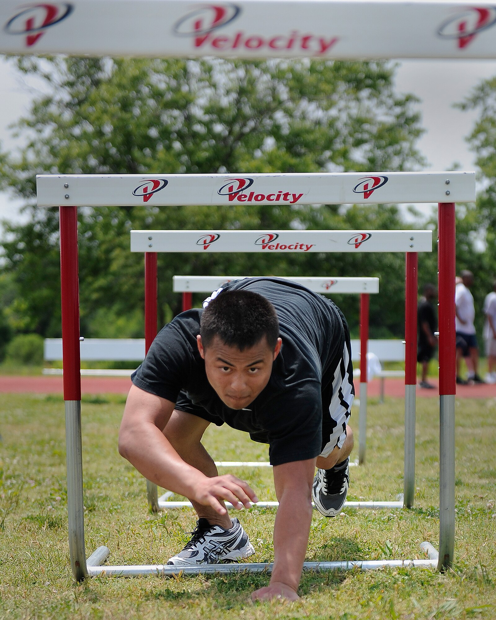 LANGLEY AIR FORCE BASE, Va. -- Airman 1st Class Jee Nou Xiong, 1st Contracting Squadron contract specialist, crawls through the obstacle course station of a Velocity class here May 29. Certified representatives from Velocity led a physical conditioning class geared toward improving overall physical performance in support of May fitness month.  (U.S. Air Force photo/Senior Airman Vernon Young)
