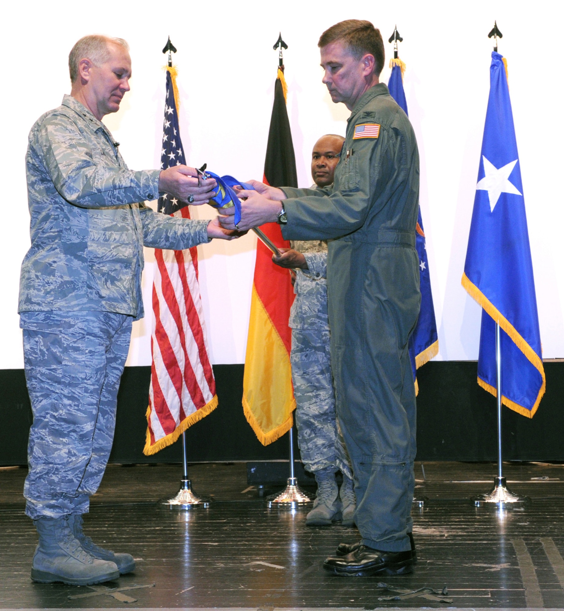 Seventeenth Air Force Commander Maj. Gen. Ron Ladnier (left), and 617th Air and Space Operations Center Commander Col. Andy Redmond (right) unfurl the 617th flag at an activation ceremony May 29 at Ramstein while AOC Superintendant Senior Master Sgt. Mike Topps assists. The ceremony marked the official standup of the AOC, the nerve center for command and control within 17th AF, the air component for U.S. Africa Command. The 617th AOC will oversee all air operations in the African area of activity. (USAF photo by Master Sgt. Jim Fisher)  