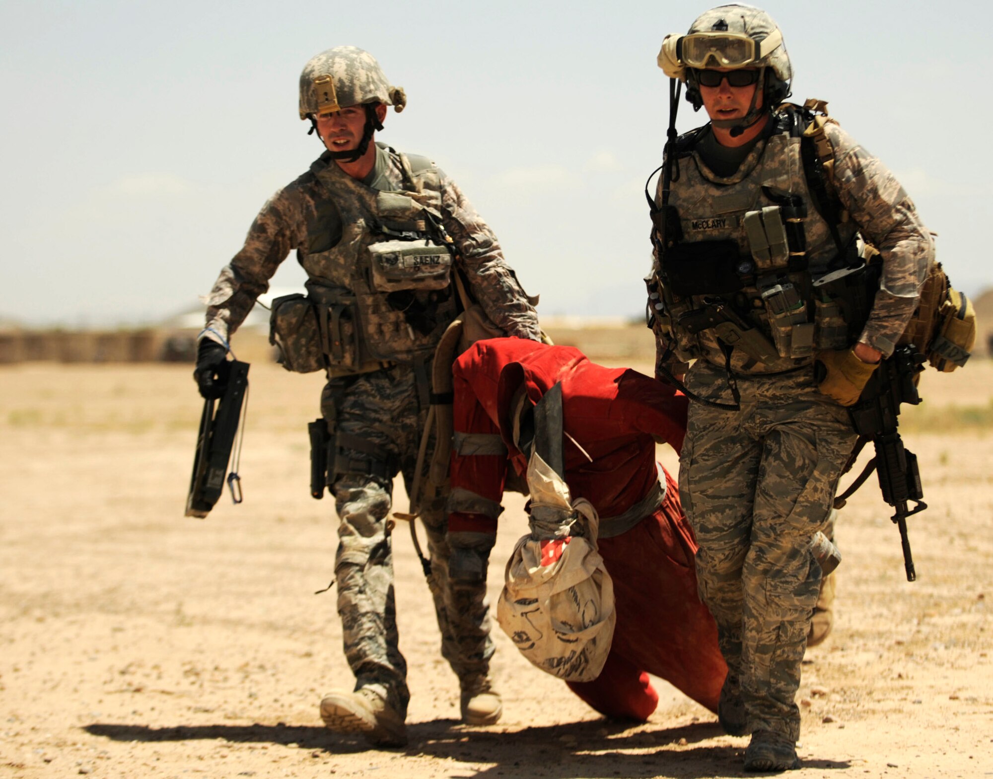 Staff Sgts. Ryan McCleary and Scott Saenz drag a simulated injured person from an improvised explosive device site during joint explosive ordnance training May 5 at Kandahar Airfield, Afghanistan. Sergeant McCleary and Saenz are both explosive ordnance disposal technicians with the 755th Explosive Ordnance Disposal unit. (U.S. Air Force photo/Staff Sgt. James L. Harper Jr.) 
