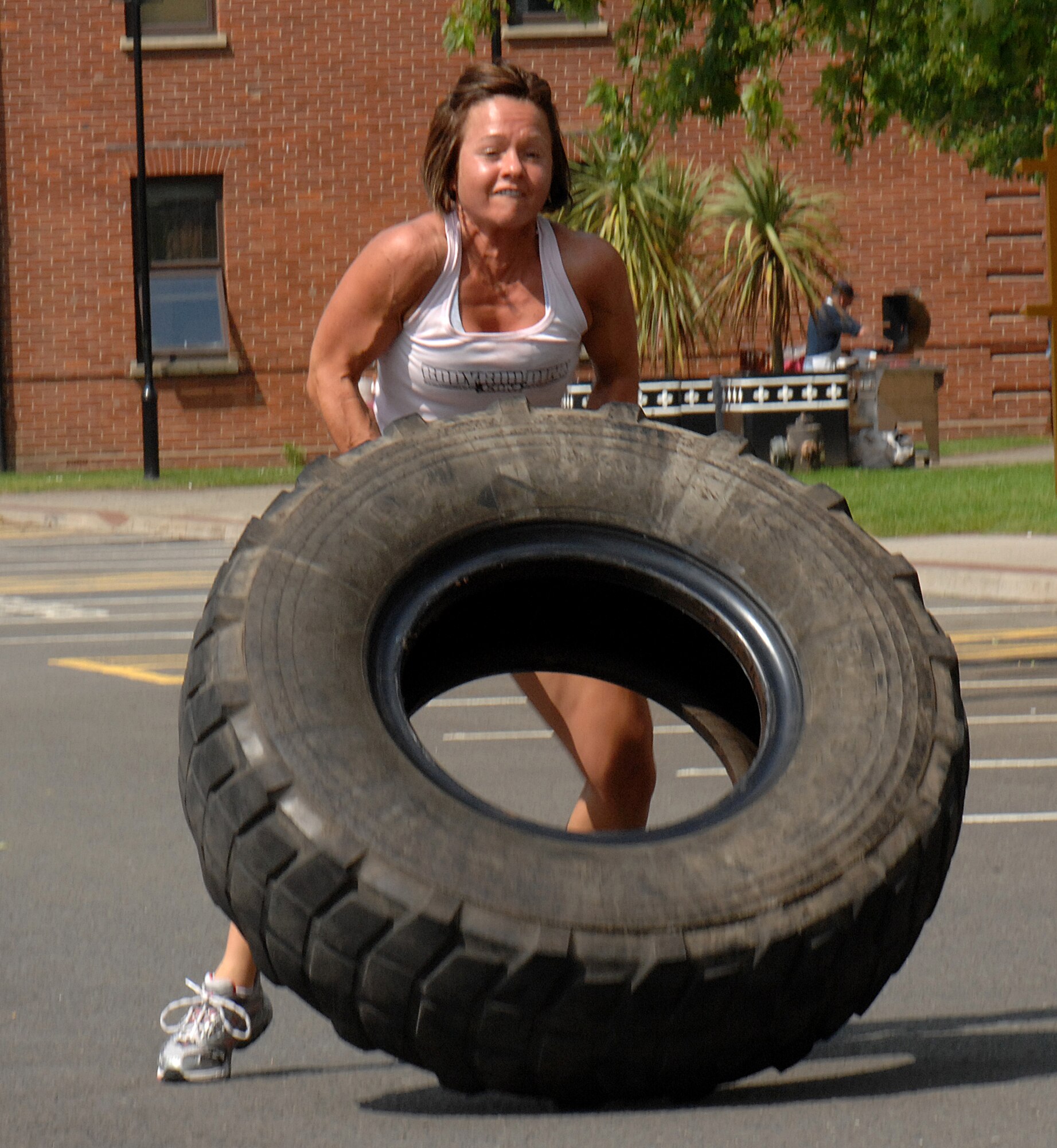 Angie Paul, a military spouse, flips a heavy tire for 75 feet as part of the fitness expo at RAF Mildenhall, England, May 29, 2009.  The contest was meant to rally excitement about fitness and being outdoors in the English summer weather.  (U.S. Air Force photo by Staff Sgt. Christopher L. Ingersoll)