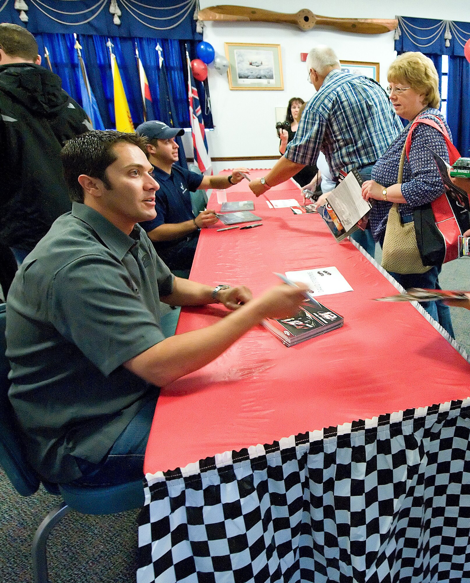 (Front) NASCAR drivers David Stremme, and (back) Reed Sorenson sign autographs at the NASCAR social May 29 at The Landings Club.  (U.S. Air Force photo/Jason Minto)