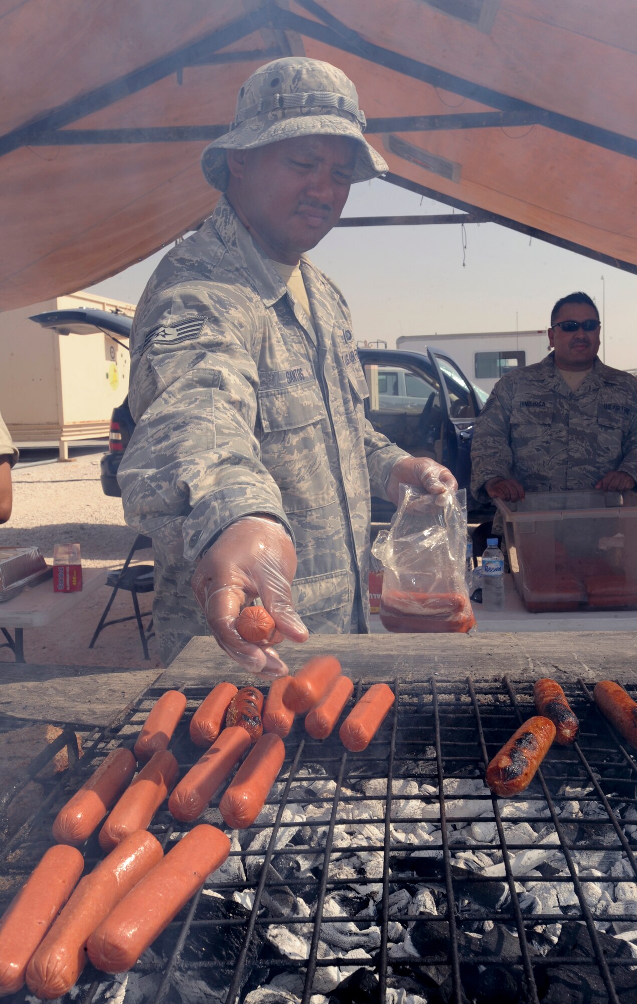 Staff Sgt. Joey Santos, a Services specialist with the 379th Expeditionary Force Support Squadron, cooks hotdogs for lunch during Flightline Fest, May 29, 2009, in an undisclosed location in Southwest Asia.  The 379th EFSS personnel provided food, beverage and musical entertainment for the half day event hosted by 379th Air Expeditionary Wing.  Personnel had the chance to look at static aircraft displays and other equipment up close, all without interrupting the mission of providing combat airpower throughout the U.S. Central Command's area of responsibility.  Sergeant Santos is native to the island of Guam, and is deployed from the Guam Air National Guard at Anderson Air Base, Guam in support of Operations Iraqi and Enduring Freedom and Combined Joint Task Force - Horn of Africa.  (U.S. Air Force Photo by Staff Sgt. Joshua Garcia/released)