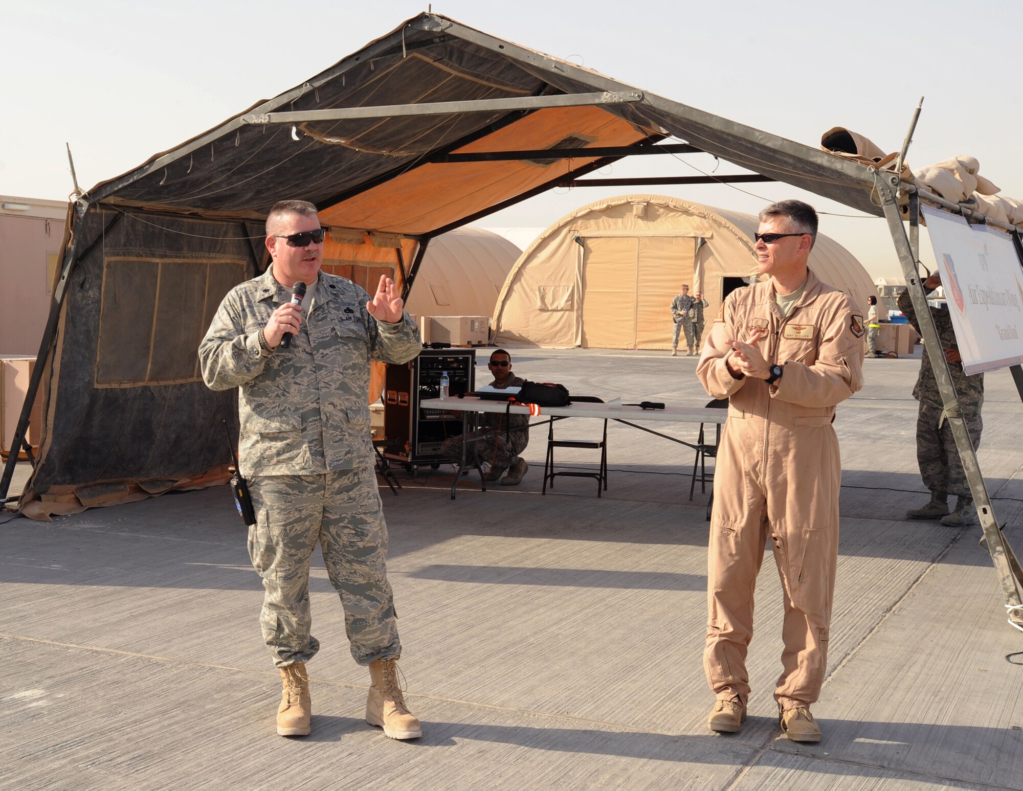 Lt. Col. Mitchell Culp, deputy commander of the 379th Expeditionary Maintenance Group speaks at the opening of Flightline Fest as the 379th Air Expeditionary Wing commander, Brig. Gen. Michael Moeller looks on, May 29, 2009, in an undisclosed location in Southwest Asia.  Lt. Col. Culp was the organizer for the event which was hosted by the 379th Air Expeditionary Wing.  The half day event gave base personnel the chance to look at static aircraft displays and other equipment up close, all without interrupting the mission of providing combat airpower throughout the U.S. Central Command's area of responsibility.  Lt. Col. Culp is from Phoenix, Ariz. and is deployed from the Arizona Air National Guard.  The 379th Air Expeditionary Wing operates in support of Operations Iraqi and Enduring Freedom and Combined Joint Task Force-Horn of Africa.  (U.S. Air Force Photo by Staff Sgt. Joshua Garcia/released)