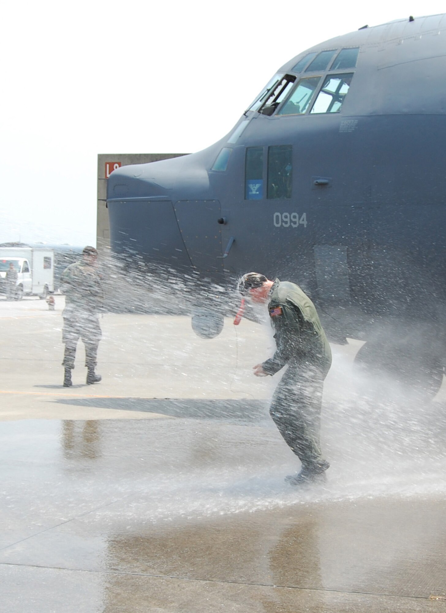 KADENA AIR BASE, Japan -- Col. David Mullins, the 353rd Special Operations Group commander, is sprayed down after stepping off a MC-130P Combat Shadow here June 1 after his final flight before moving on to his next assignment. The colonel flew in both a MC-130H Combat Talon II and MC-130P for his final flight. (U.S. Air Force photo by James D'Angina) 
