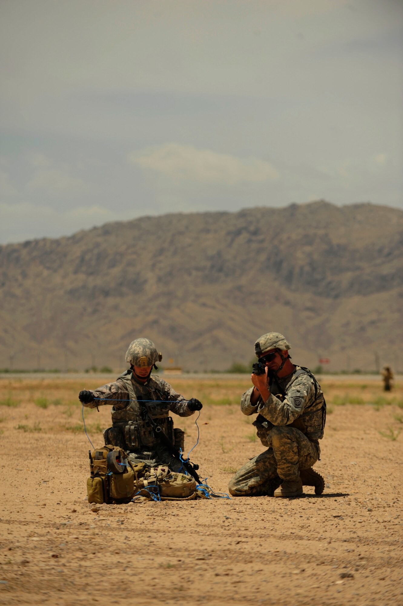 Staff Sgt. Scott Saenz, an Explosive Ordinance Disposal technician, 755th Explosive Ordinance Disposal, prepares a drag line, while being covered by Army Sgt. Mike Ridgeway, 82nd Airborne division, during joint improvised explosive device training at Kandahar Airfield, Afghanistan, on May 5, 2009, in support of Operation Enduring Freedom.  (U.S. Air Force photo by Staff Sgt. James L. Harper Jr.)