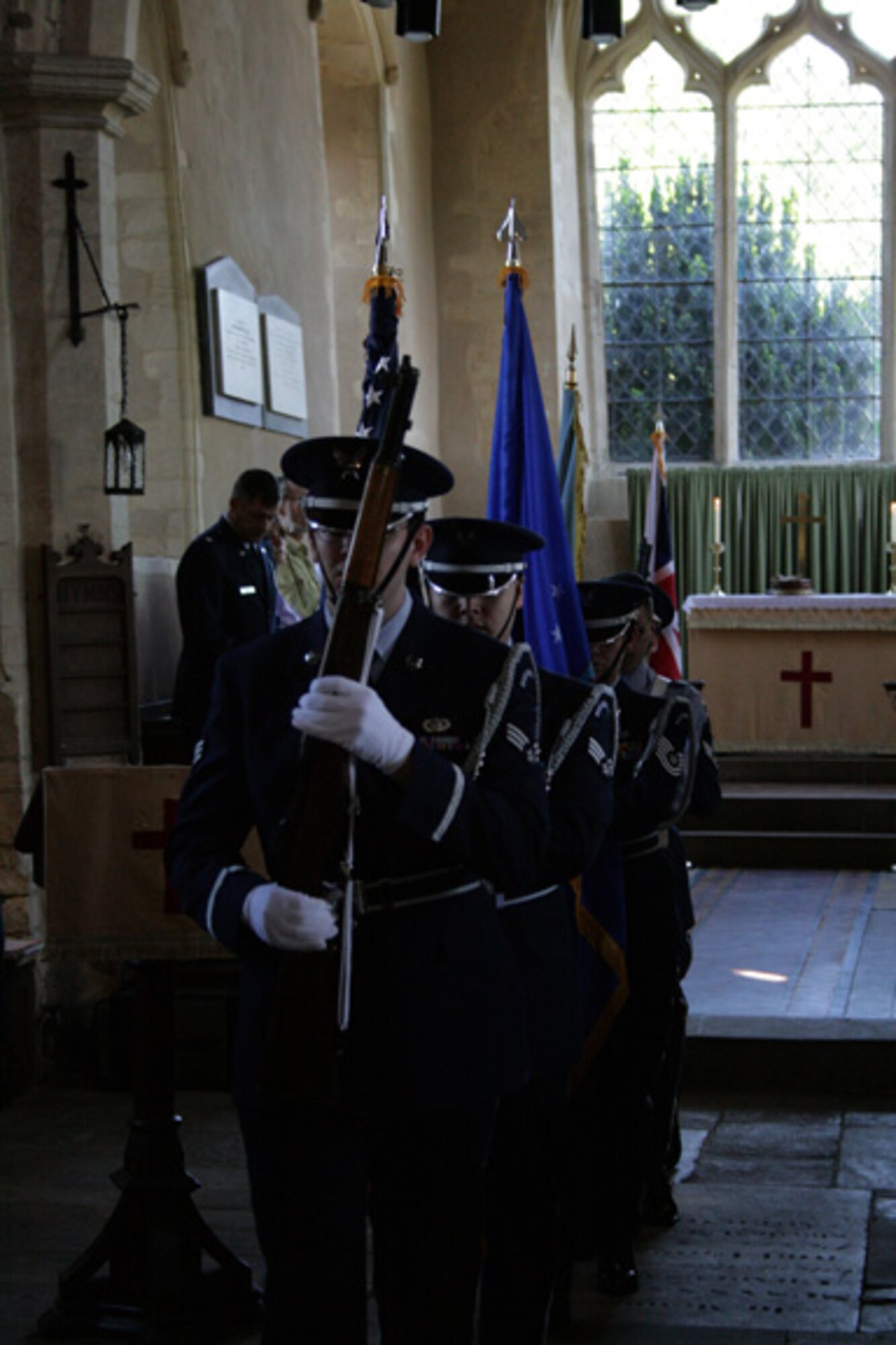 Members of the Tri-Base Honor Guard retire the colors at a memorial dedication service at St. Mary's Church, Yelden, Bedfordshire. The service honored U.S. military personnel who died March 24, 1944 when a B-17 Flying Fortress crashed upon takeoff from RAF Cheveston. The crash killed 11 aircrew members, eight military personnel on the ground and two children from the village. 
