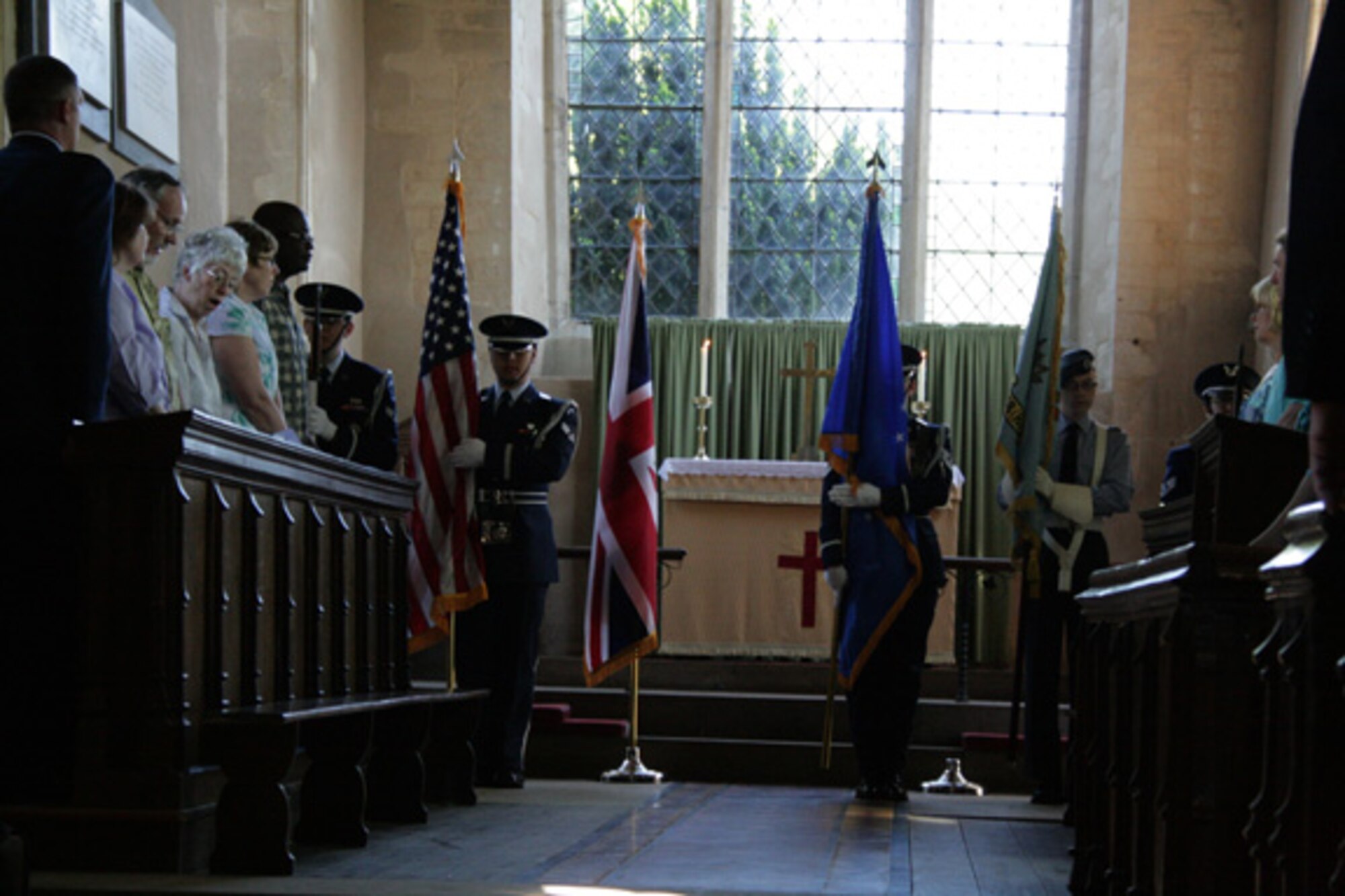 Members of the RAF Alconbury Honor Guard post the colors at a memorial dedication service at St. Mary's Church, Yelden, Bedfordshire. The service honored U.S. military personnel who died March 24, 1944 when a B-17 Flying Fortress crashed upon takeoff from RAF Cheveston. the crash killed 11 aircrew members, eight military personnel on the ground and two children from the village. 