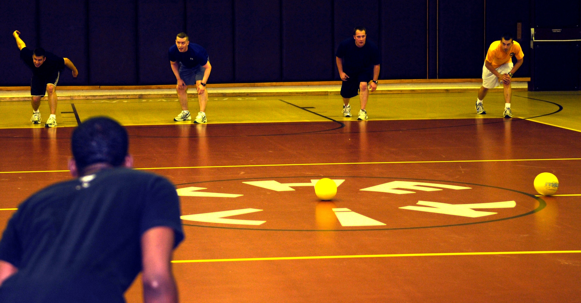 Teams representing the 90th Expeditionary Air Refueling Squadron and the 39th Medical Operations Squadron wait for the call of "dodgeball" to start a match during late-night dodgeball May 29, 2009, at the Incirlik Fitness Center.  The two teams were the only to show up for the event in which the 39th MDOS won the first seven matches.  However, the 817th EARS came back to win the next four before the teams called it quits.  (U.S. Air Force photo/Staff Sgt. Raymond Hoy)