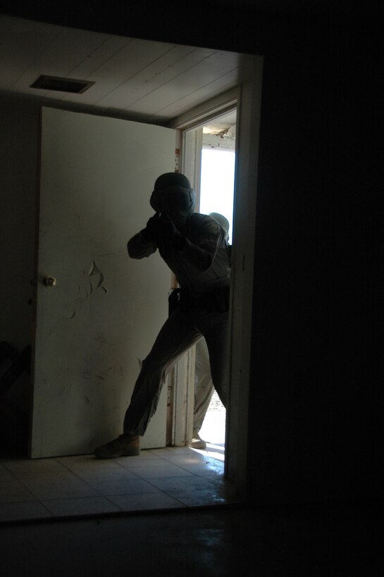 Lance Cpl. Malcolm Aranda, military policeman, enters a room during a school shotting simulation June 2, 2009, in a training house at the Marine Corps Air Station in Yuma, Ariz. The exercise, which included the use of nonlethal live ammunition, was designed to improve the officers' tactics and confidence in shootouts.