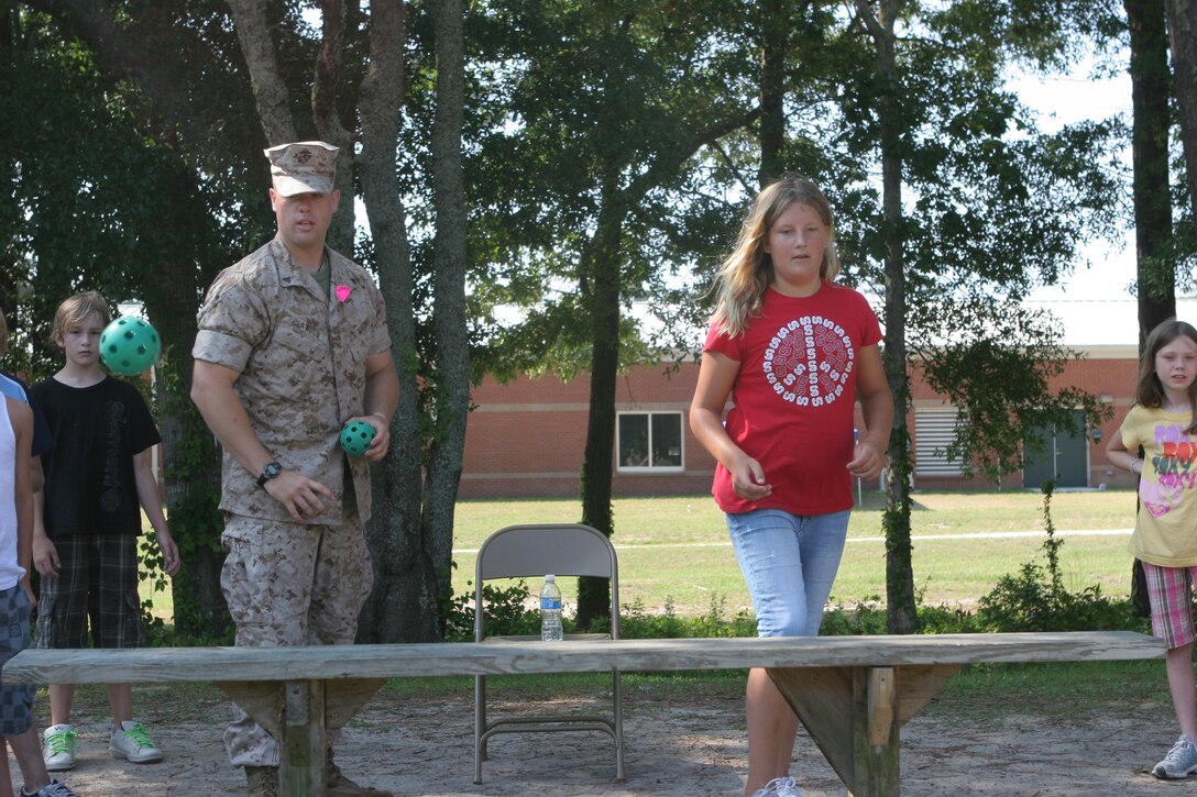 Cpl. Michael Clawson of 2nd Battalion, 6th Marine Regiment, 2nd Marine Division  participates in a ball toss challenge against fourth-grader Sarah Staeble at White Oaks Elementary, 2 June 2009.  Marines from 2/6 volunteered at the White Oaks Elementary field meet. (Official USMC photo by Cpl. Jesse J. Johnson) (Released)