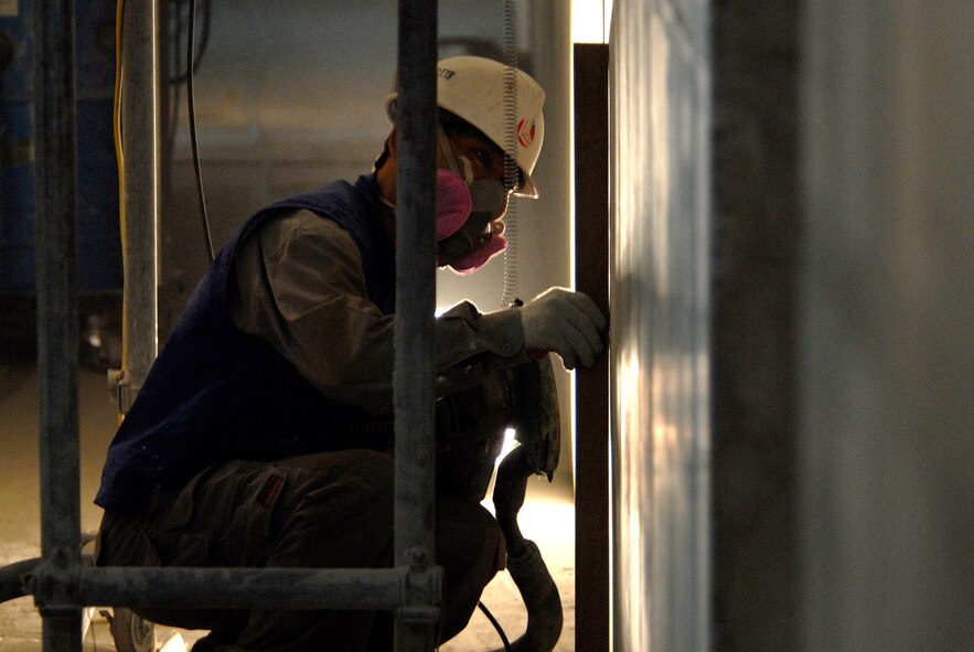 A contractor at Kunsan Air Base, Republic of Korea, sand the walls of new dormitory to a desired smoothness, June 03, 2009. The new dorm is scheduled to be completed in 2010. (U.S. Air Force Photo by SSgt Jason Colbert)





