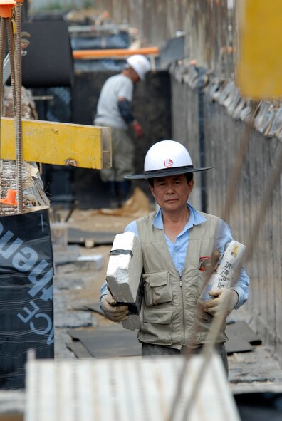 Contractors working at Kunsan Air Base, Republic of Korea, lay plumbing and water-proofing material into the  foundation of a new dormitory, June 03, 2009. The new dorm is scheduled to be completed in 2010. (U.S. Air Force Photo by SSgt Jason Colbert)